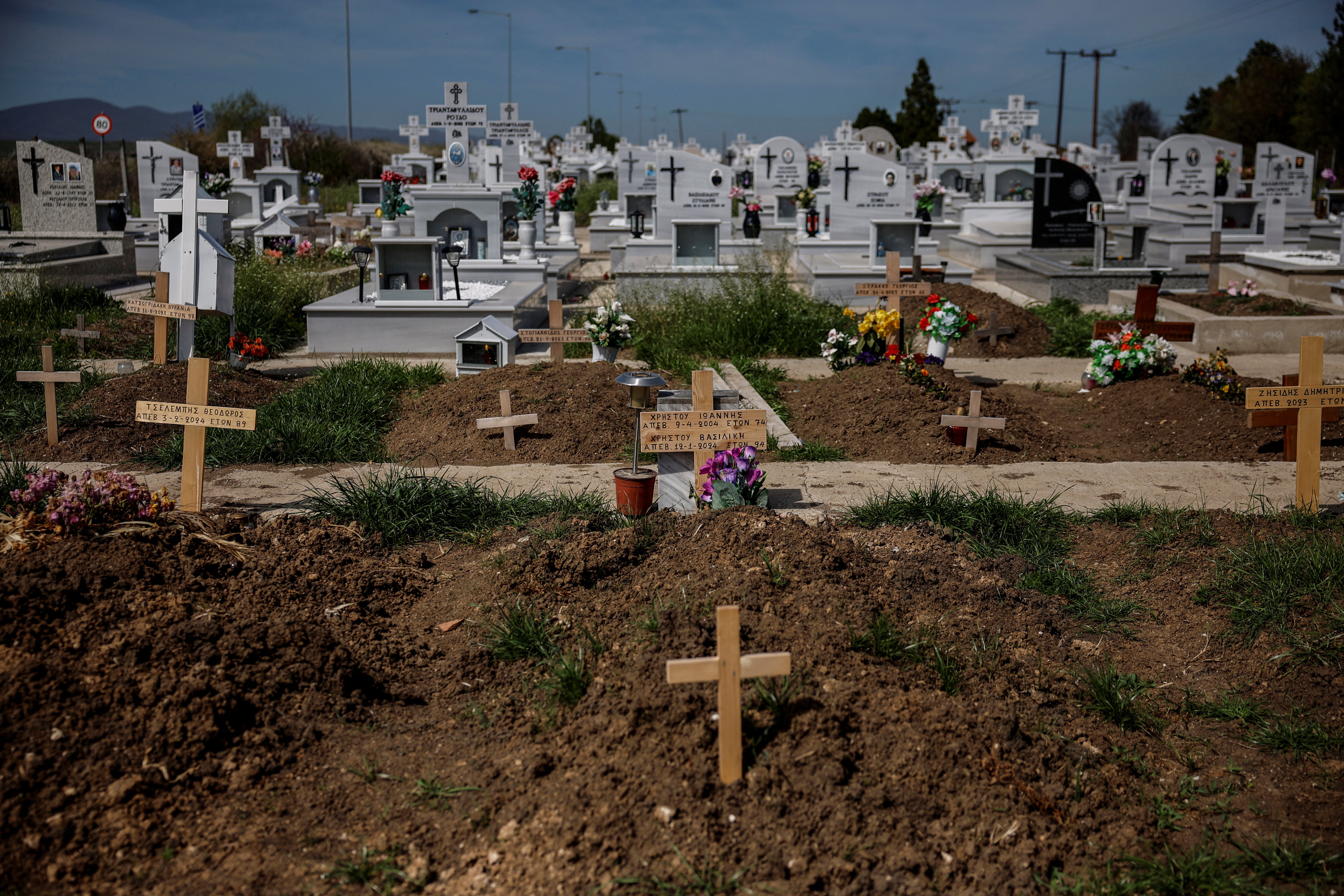 New graves are seen at the cemetery in the village of Ormenio, Greece