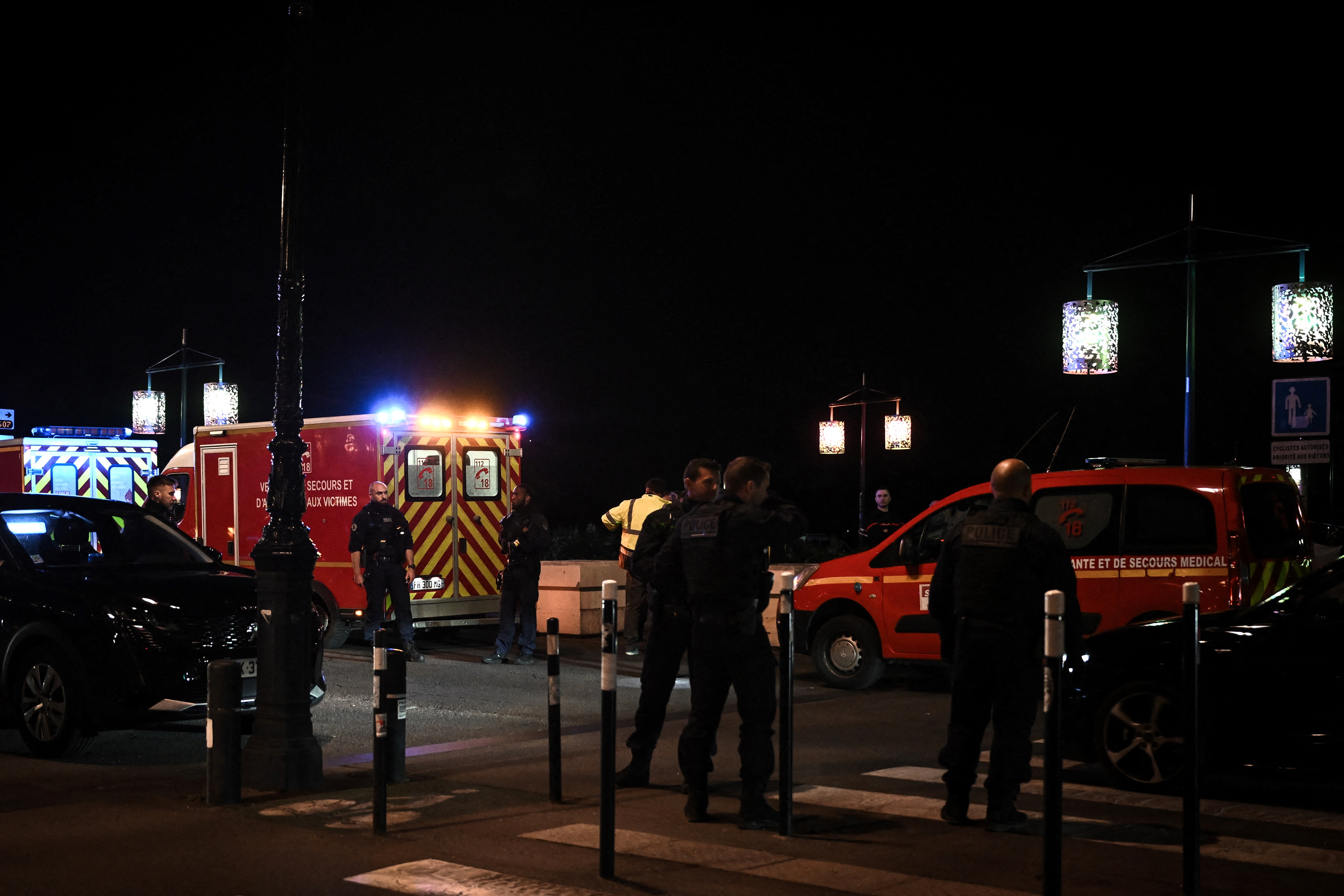 Police officers stand in a street after a man stabbed and killed one person and injured another before being killed by police as he fled, in Bordeaux, south-western France, on April 10, 2024