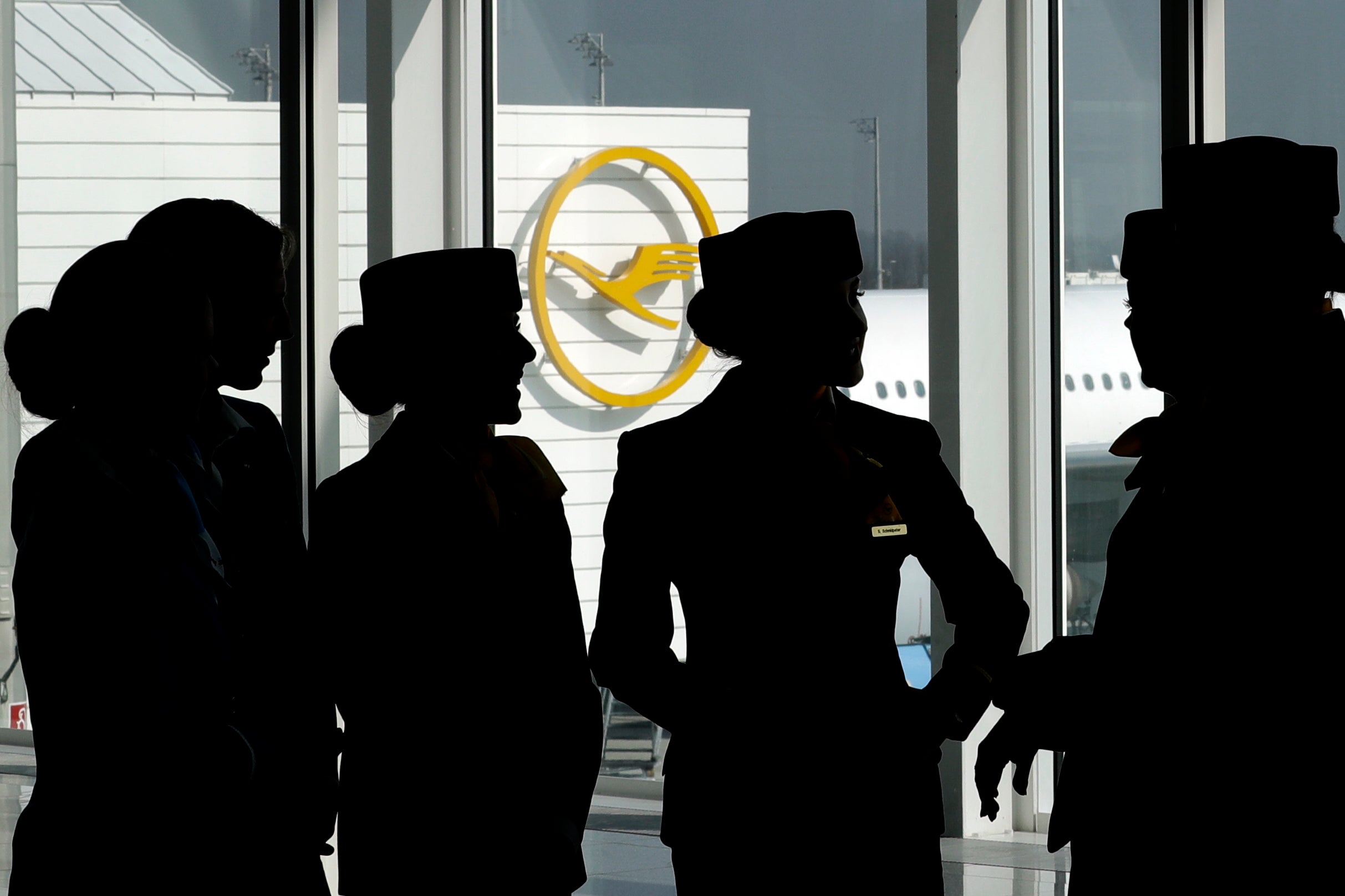 Lufthansa flight attendants silhouetted as they pose for a photograph on occasion of the company's annual press conference in Munich, Germany