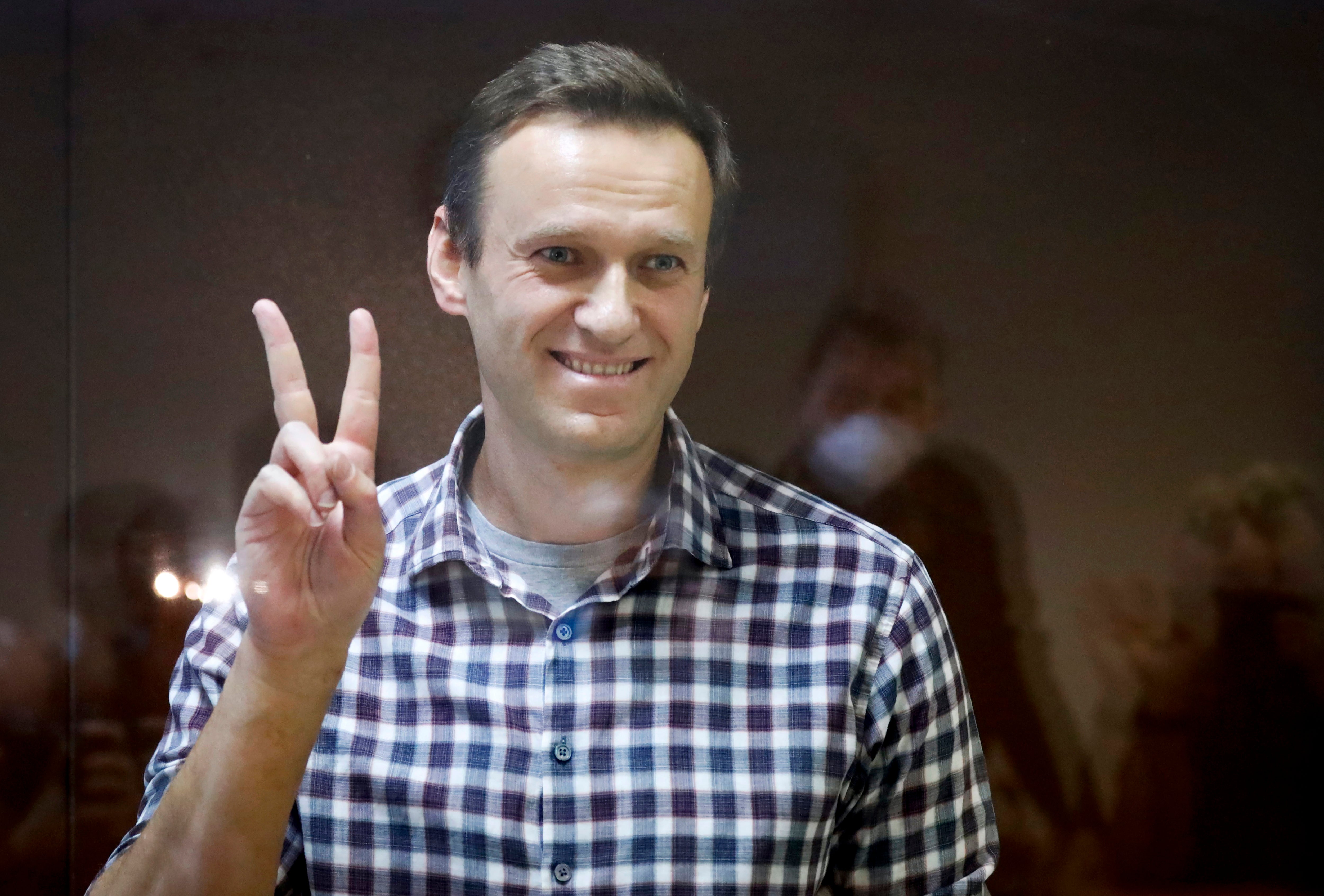 Russian opposition leader Alexei Navalny gestures as he stands in a cage in the Babuskinsky District Court in Moscow, Russia, Saturday, 20 Feb 2021