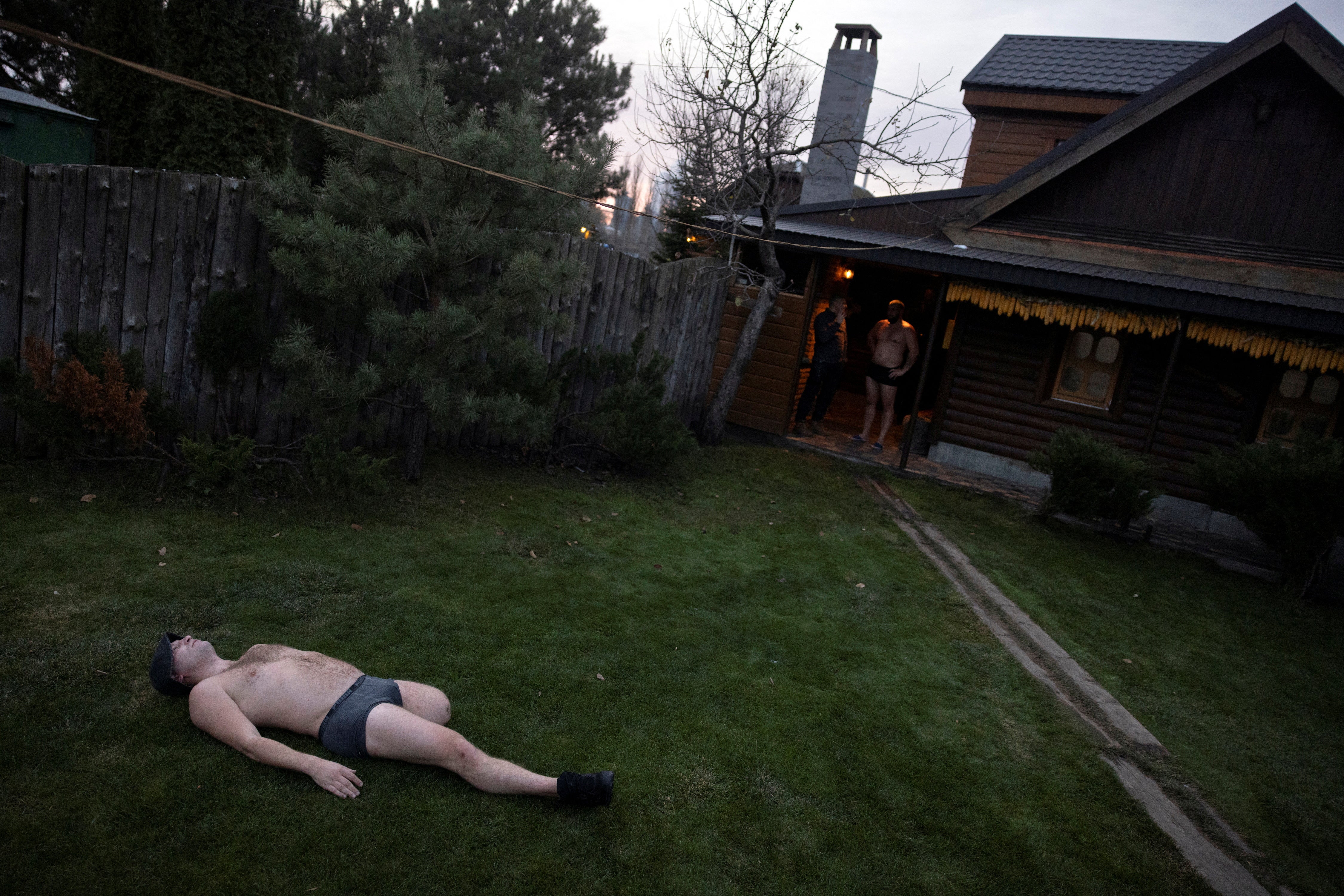 Oleksandr Revtiukh, 33, a Ukrainian serviceman who lost his left arm and most of his left leg in multiple mine blasts in 2023, cools off after spending time in a sauna with a friend in his hometown, during his first visit after his injury amid Russia's attack on Ukraine, in Nizhyn, Ukraine