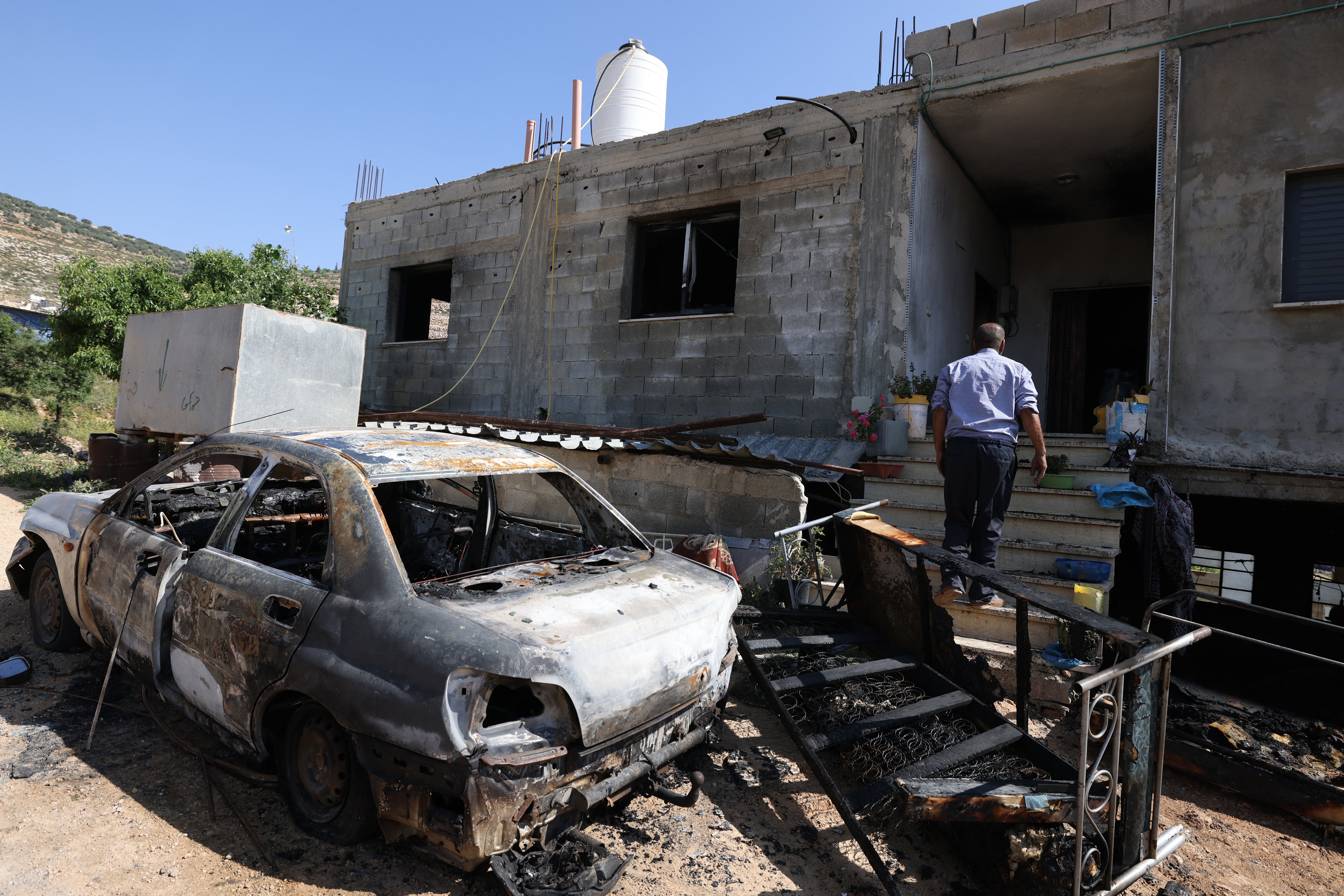 A Palestinian inspects damage to a home in the village of Mughayir in the Israeli-occupied West Bank on Saturday after an attack by Israeli settlers