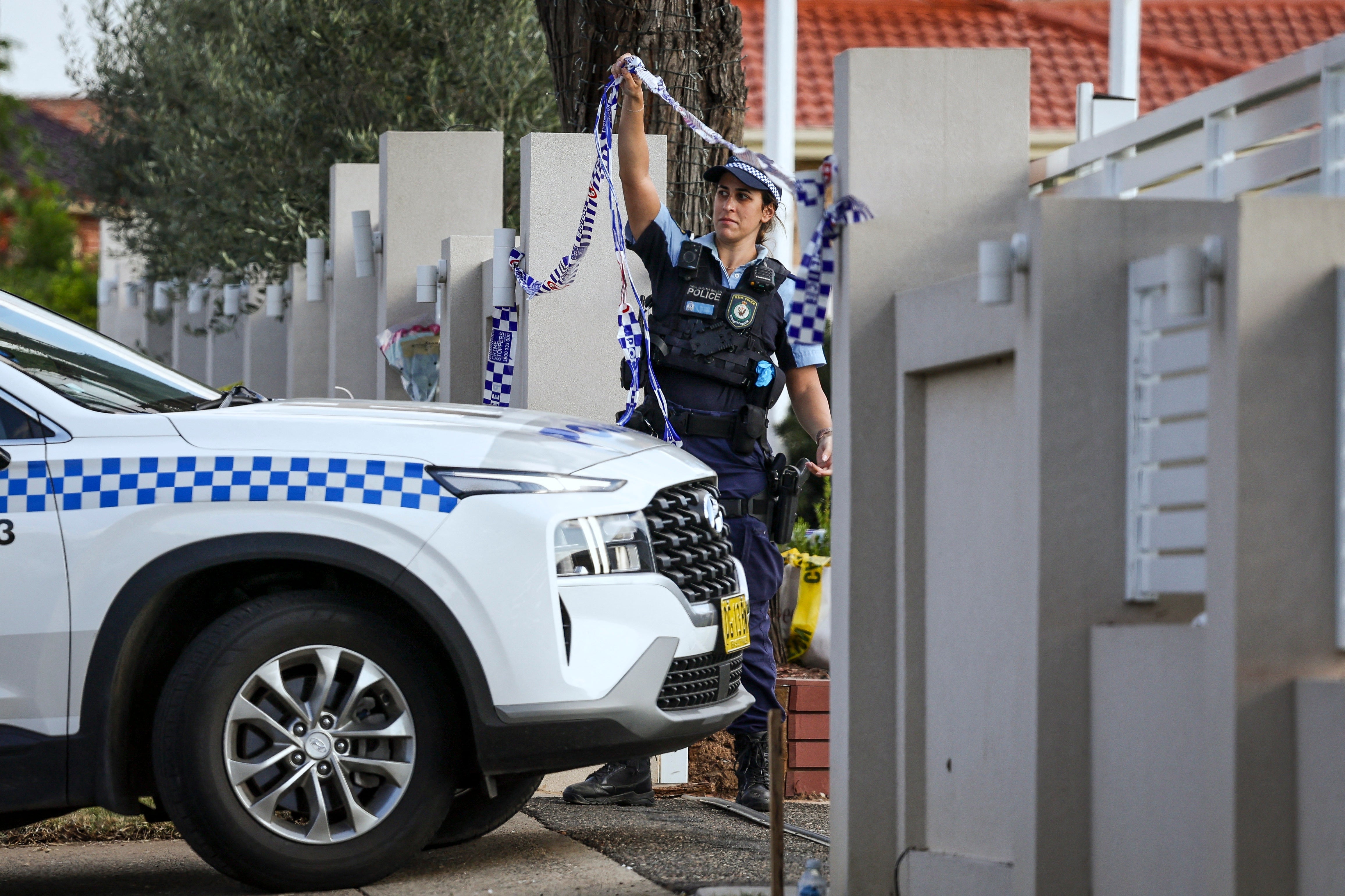 A police officer lifts tape to let a car into the Christ the Good Shepherd Church in Sydney’s western suburb of Wakeley on 16 April 2024