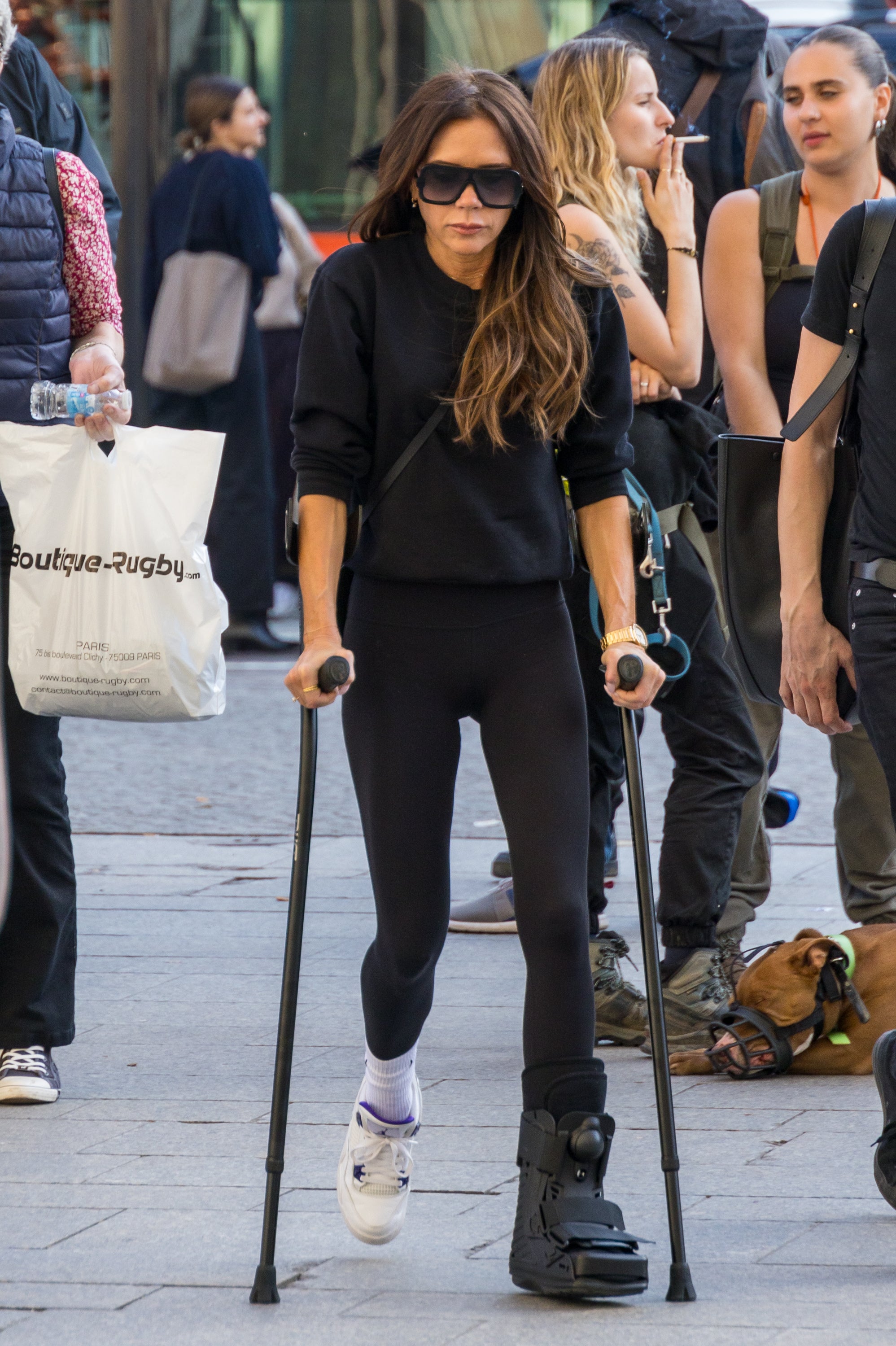 Break it like Beckham: Victoria hobbling around Paris with a foot injury