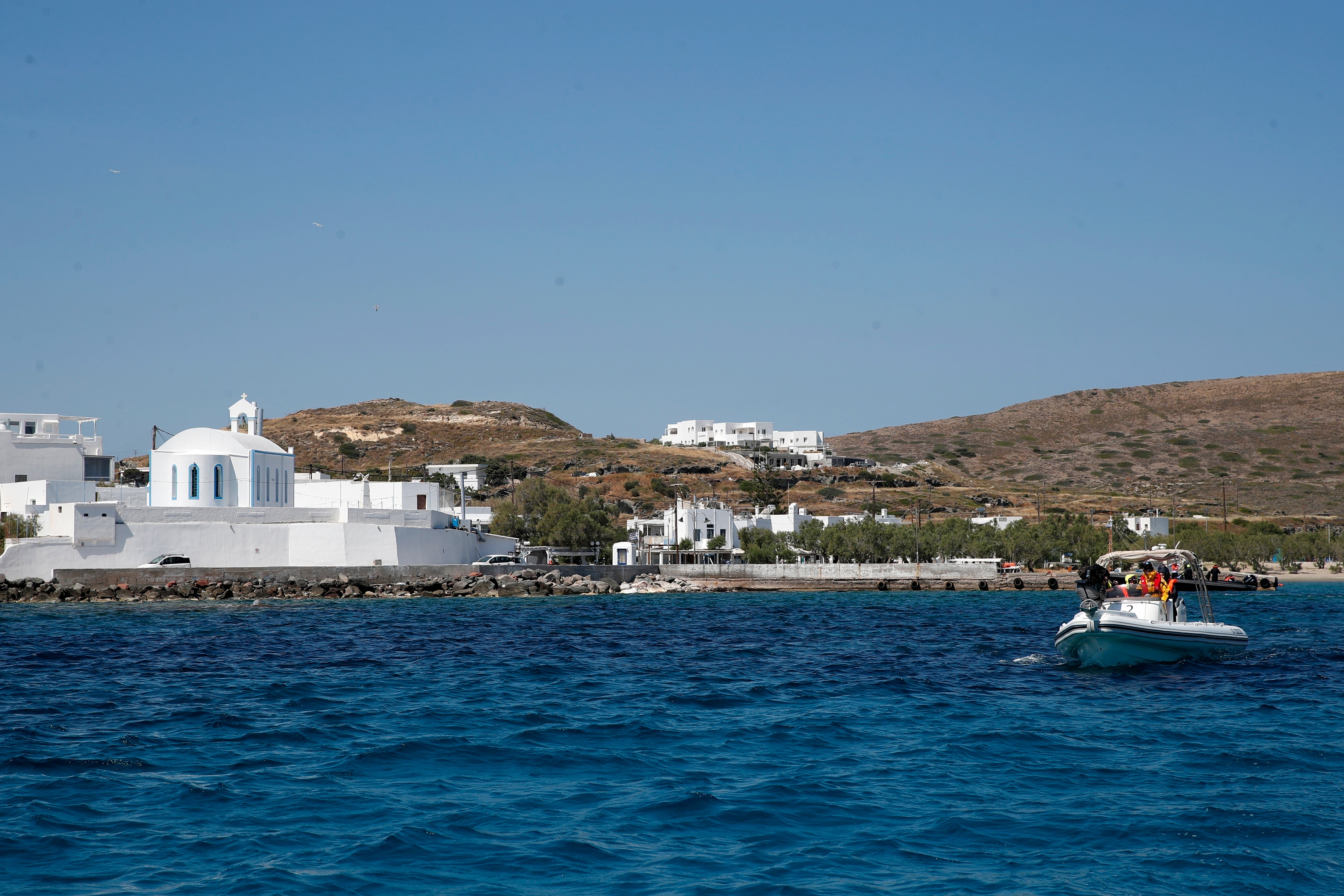 Medical staff in a dinghy leaves from the Aegean Sea island of Milos to Sikinos island, Greece