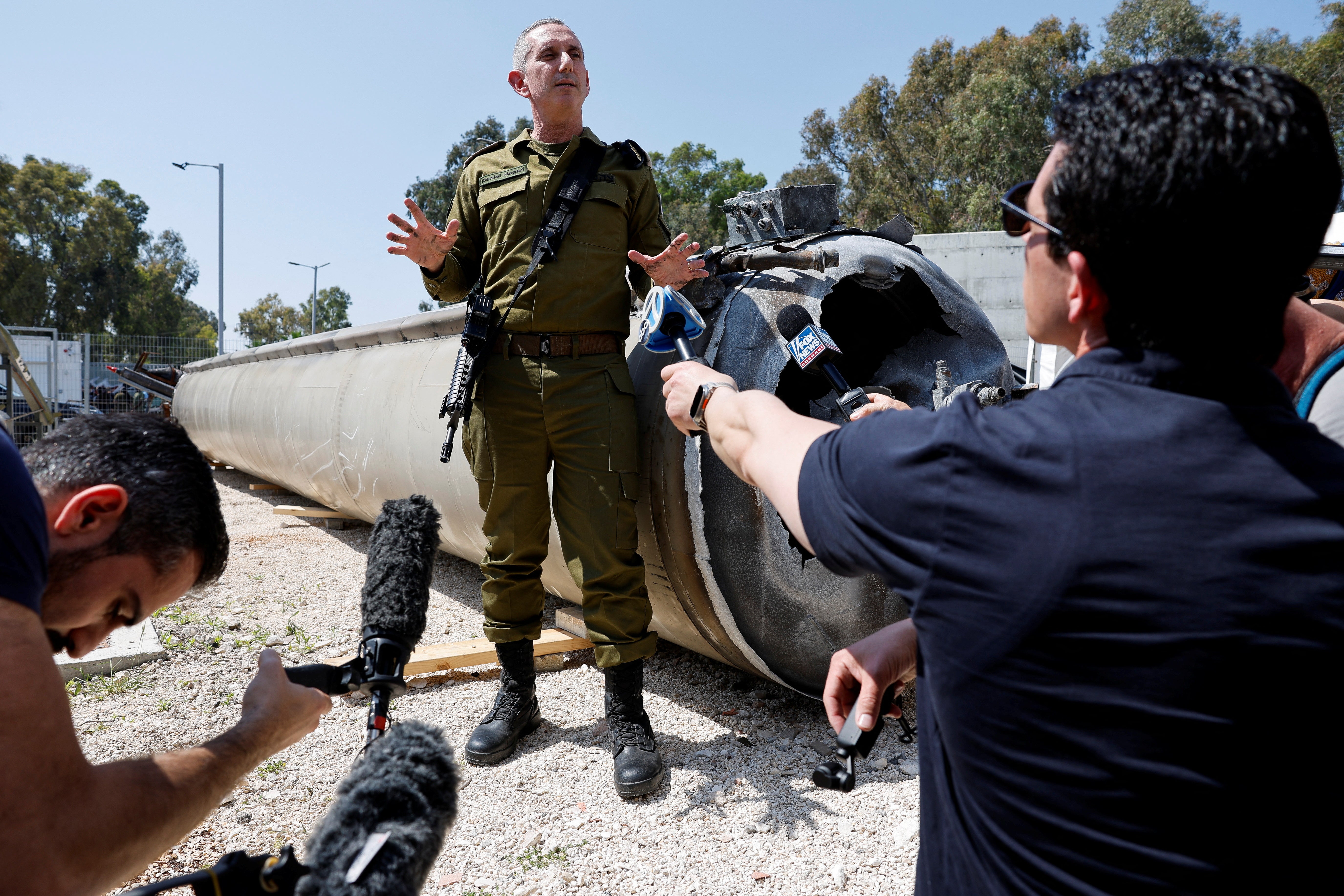 Israeli military spokesperson Rear Admiral Daniel Hagari stands next to an Iranian ballistic missile which they say was retrieved from the Dead Sea