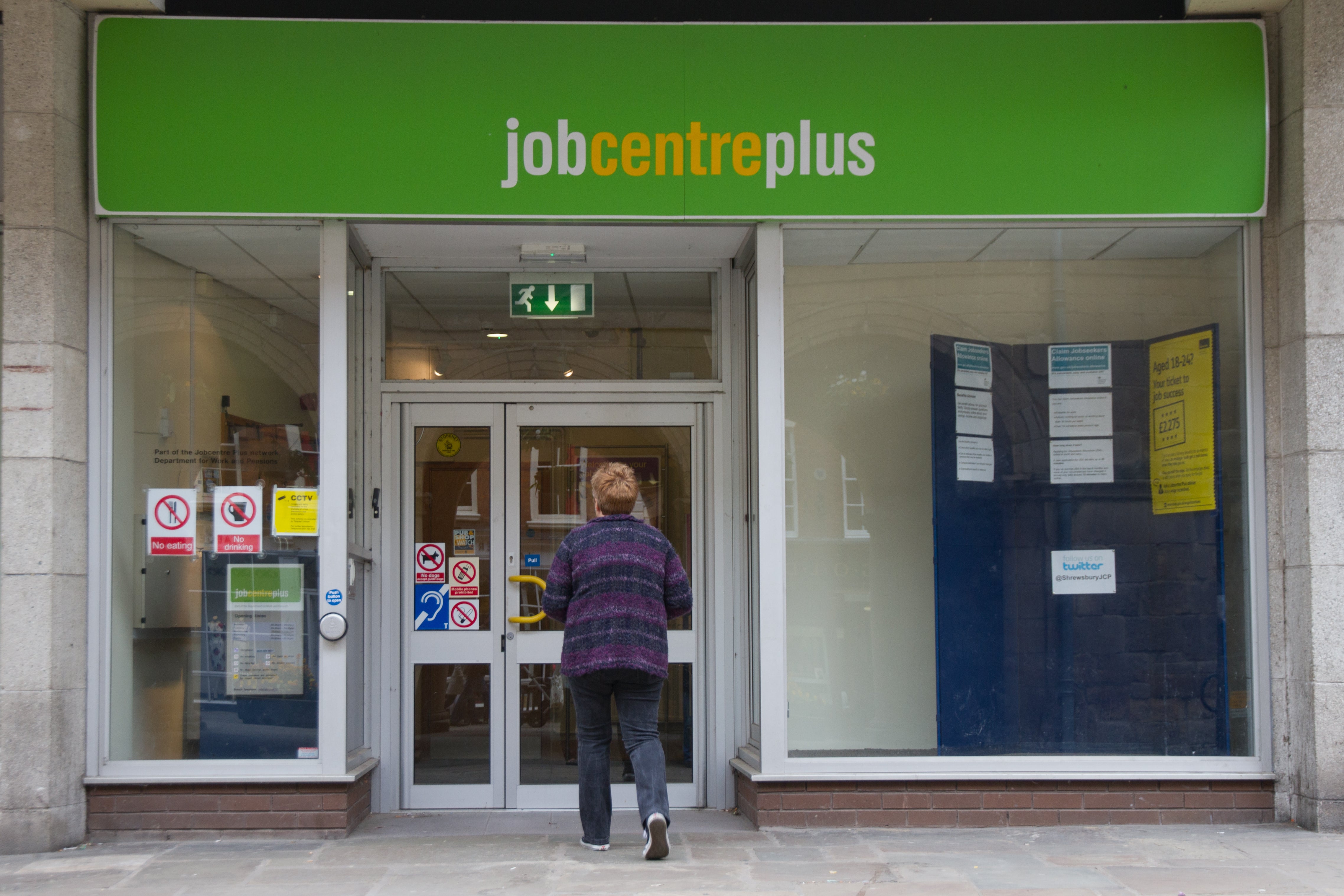 A woman walks towards the door of Job Centre Plus in Shrewsbury town center, Shropshire