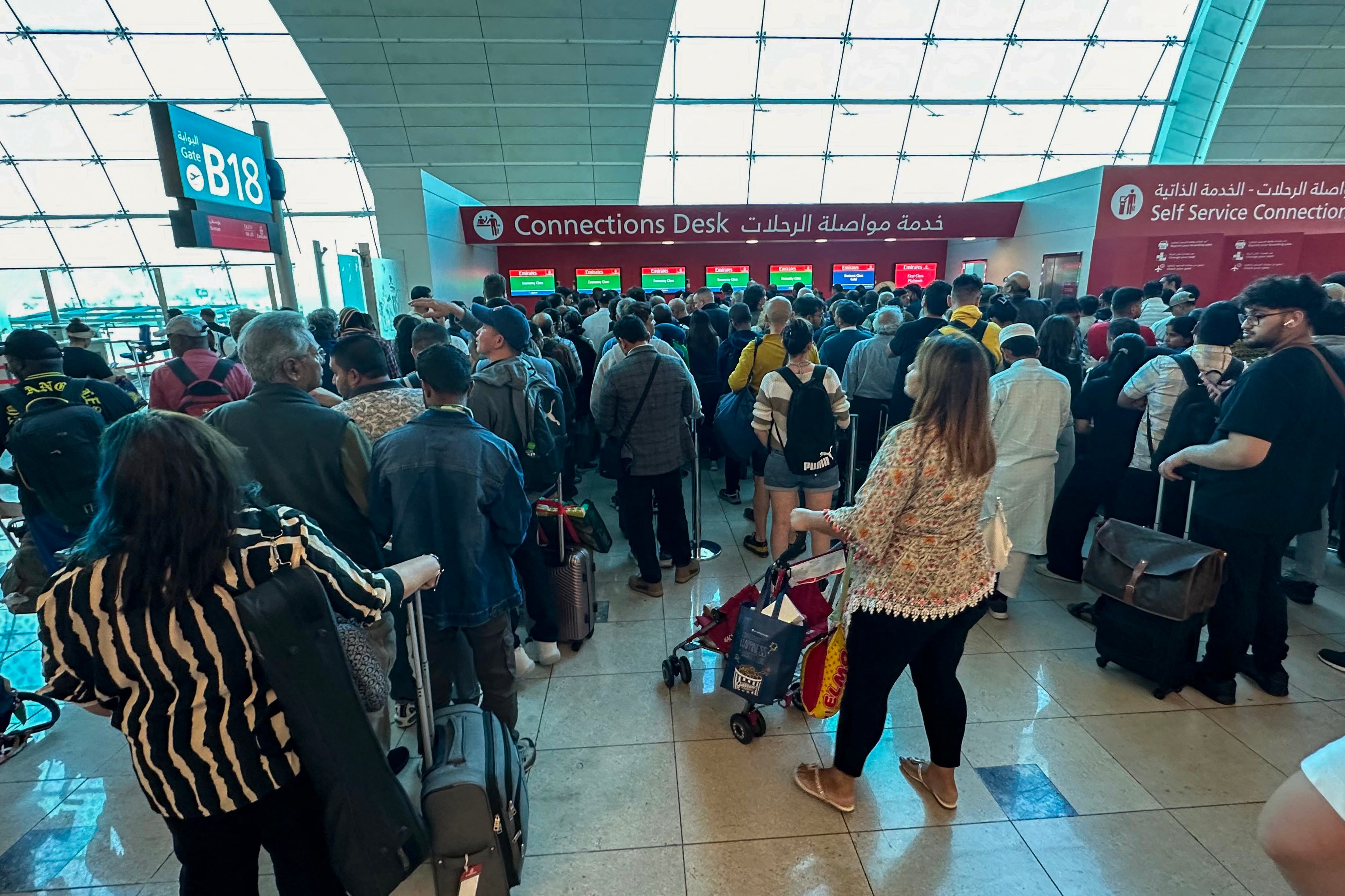 Passengers queue at a flight connection desk at the Dubai International Airport in Dubai on April 17, 2024