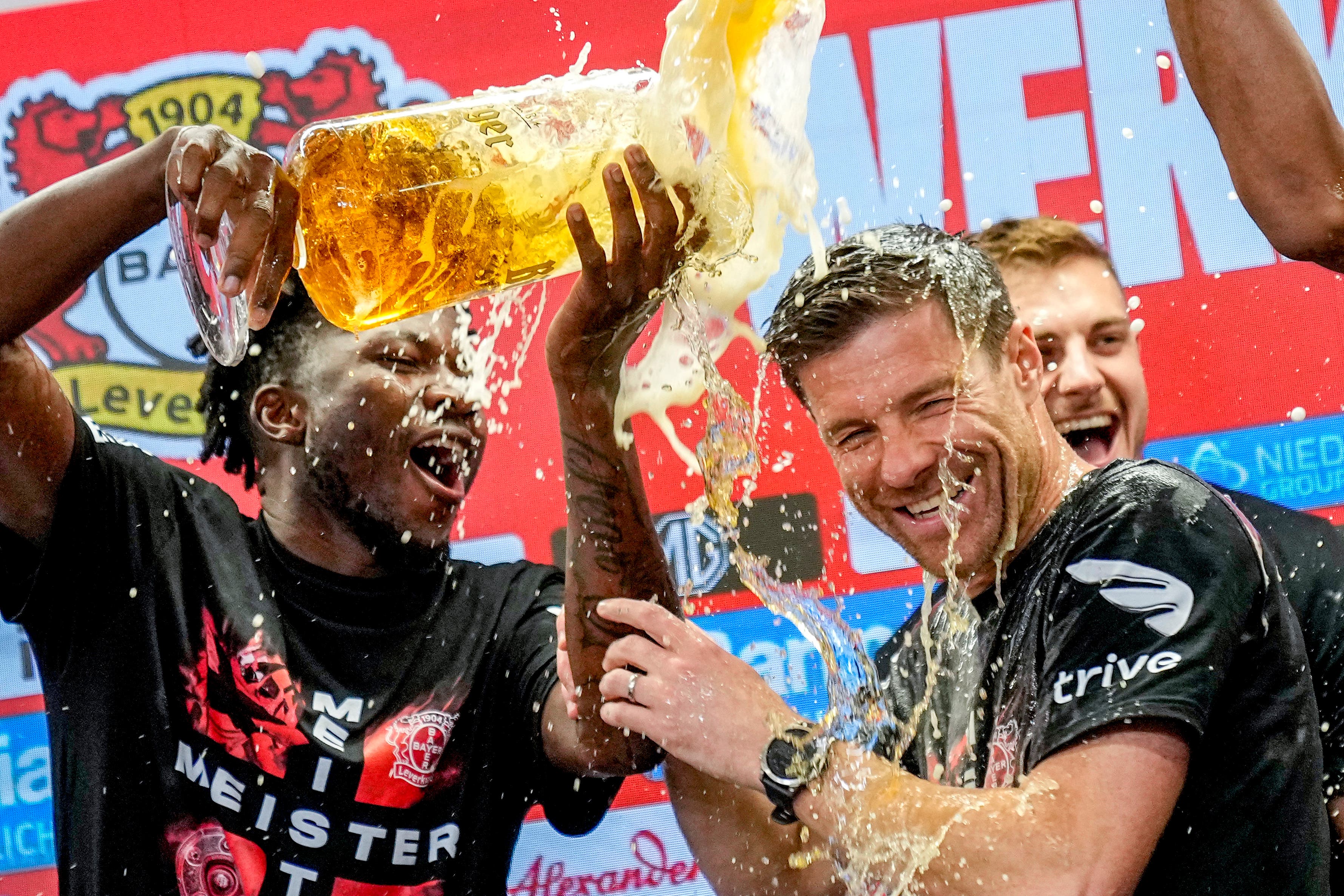 Leverkusen’s head coach Xabi Alonso, centre, is sprayed with beer after Bayer Leverkusen won the Bundesliga title (AP Photo/Martin Meissner)