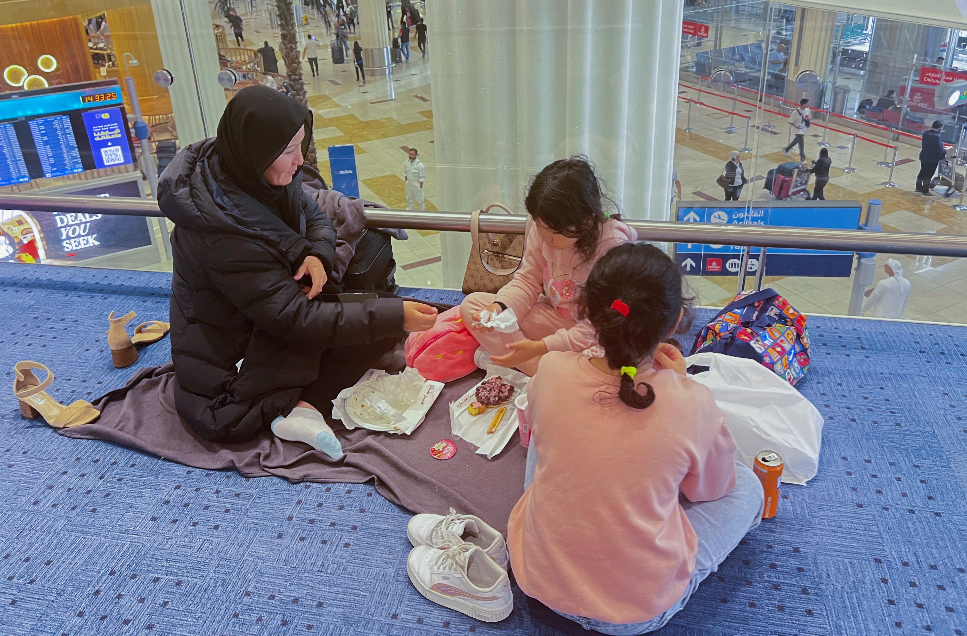 Going nowhere: A family stranded at Dubai airport after severe flooding and mass cancellations