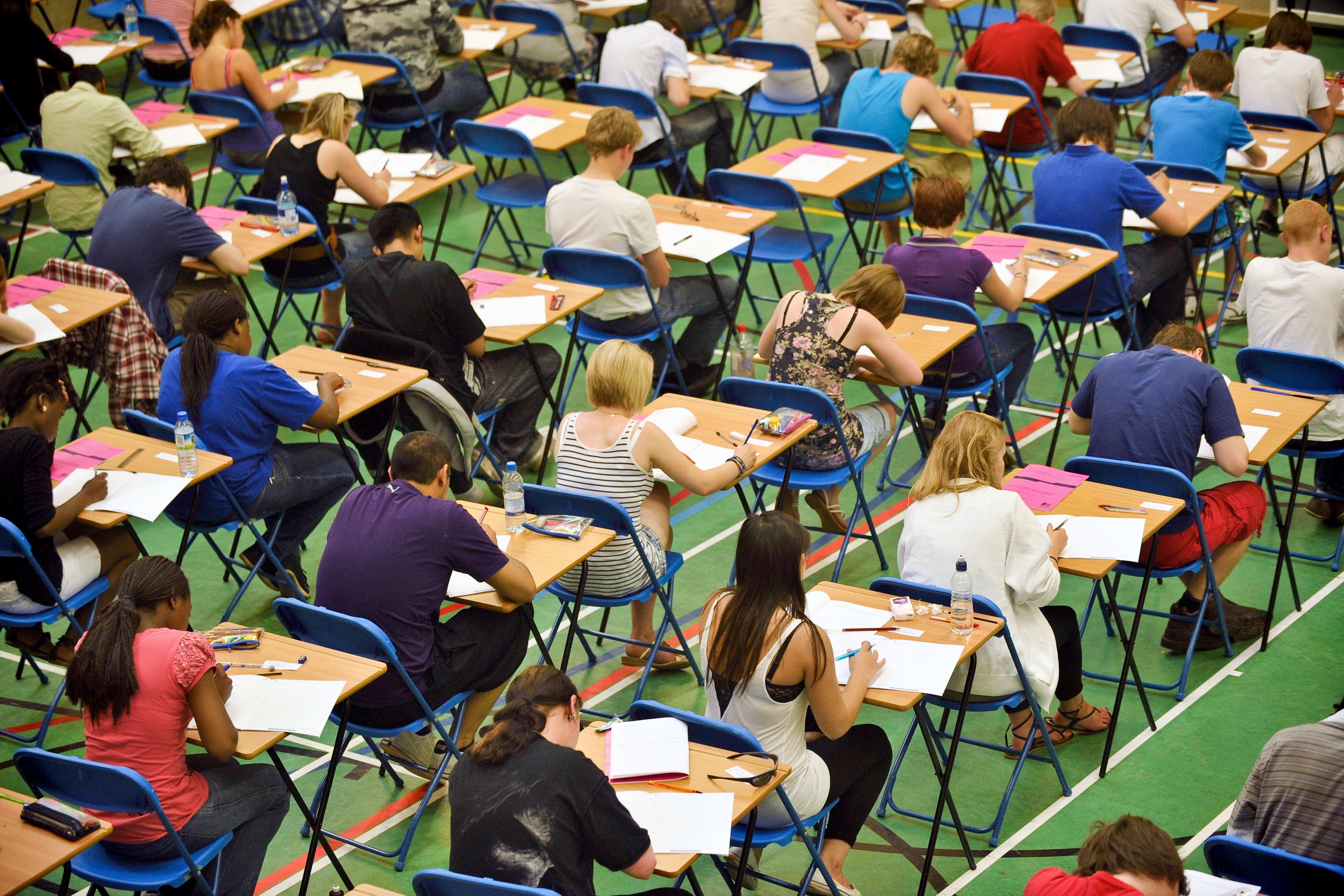 A-level students sit an A-level maths exam inside a sports hall