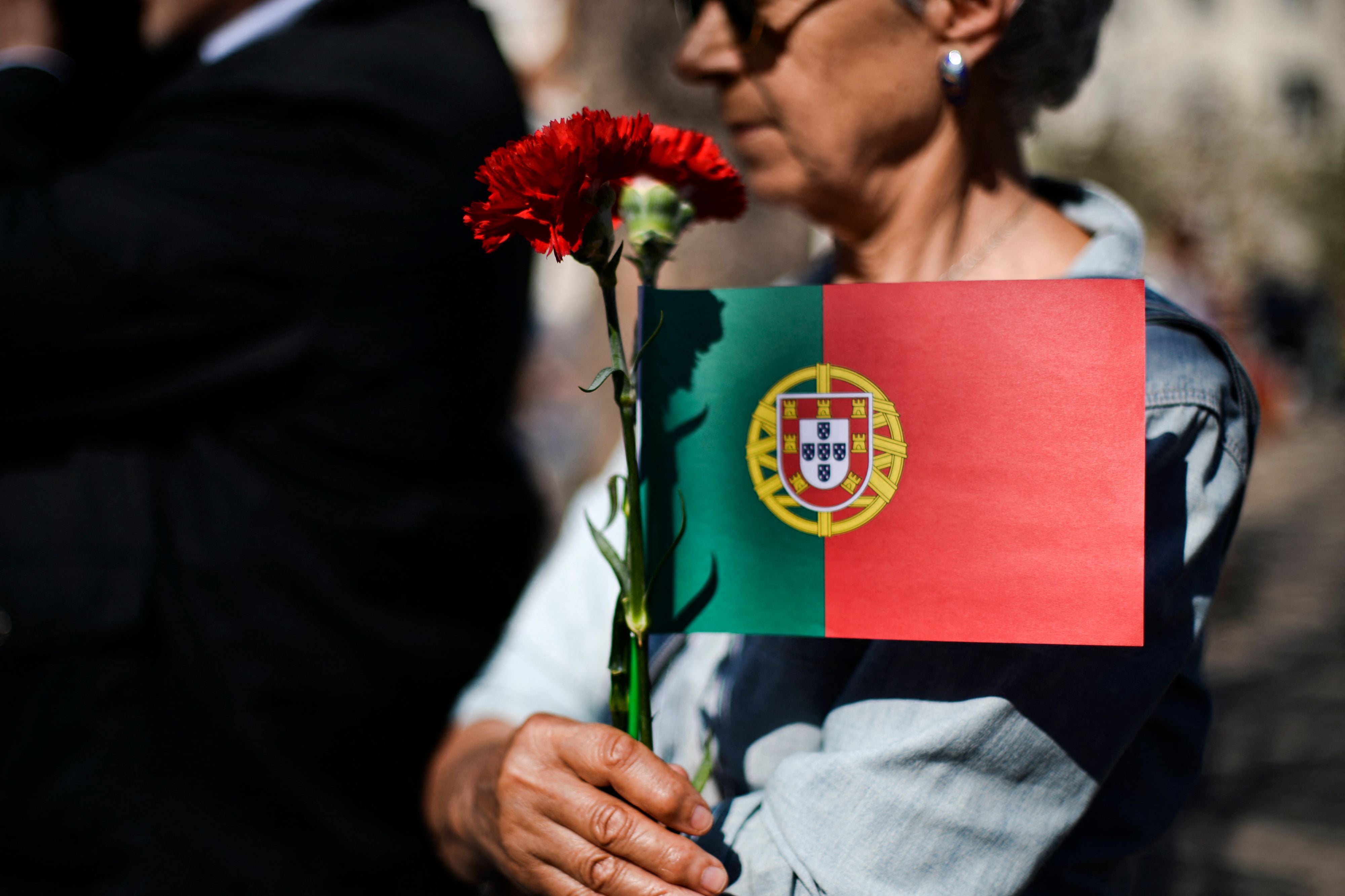 A women holds a carnation at a rally to commemorate the revolution