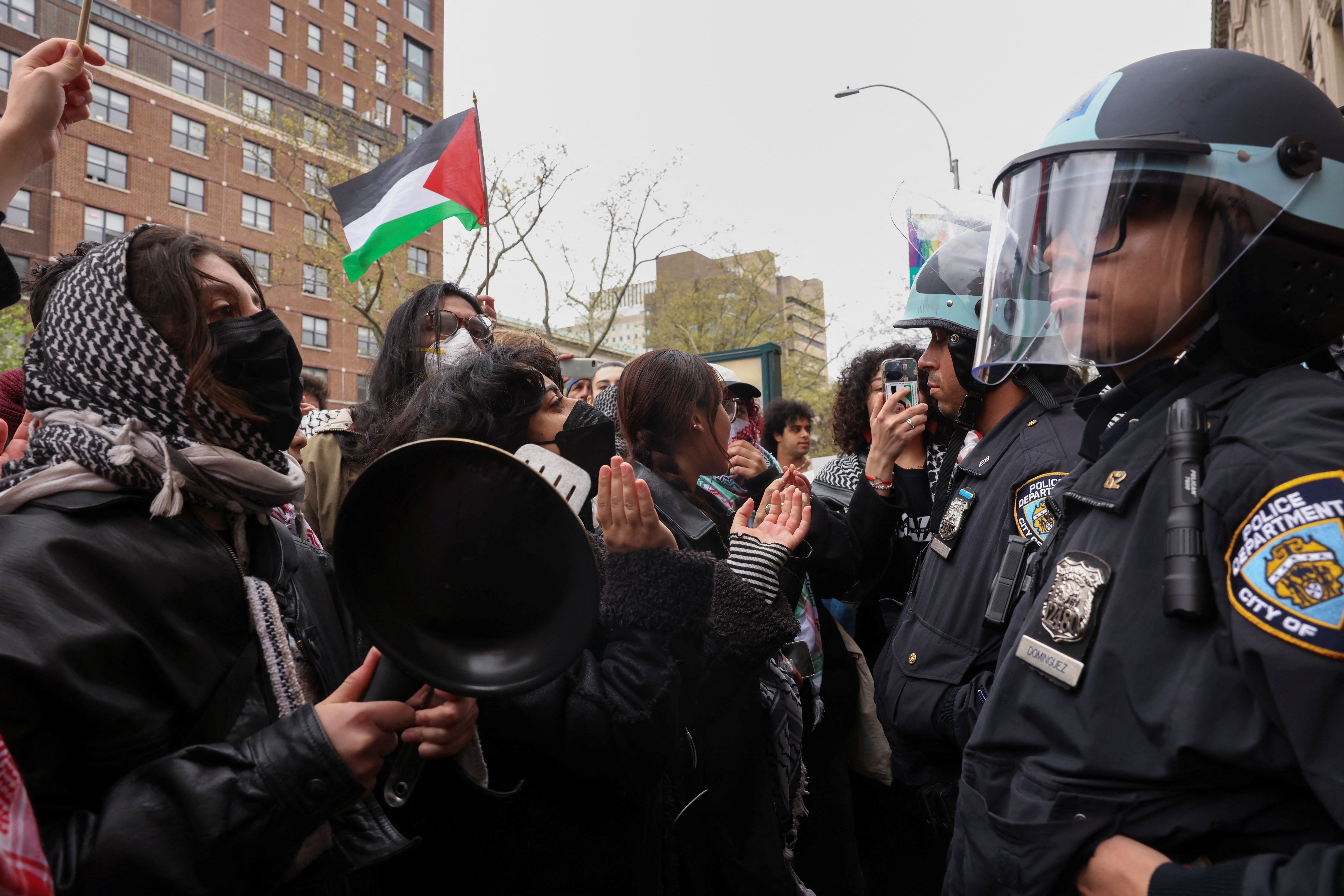 Police officers stand guard as demonstrators protest in solidarity with Pro-Palestinian organizers on the Columbia University campus