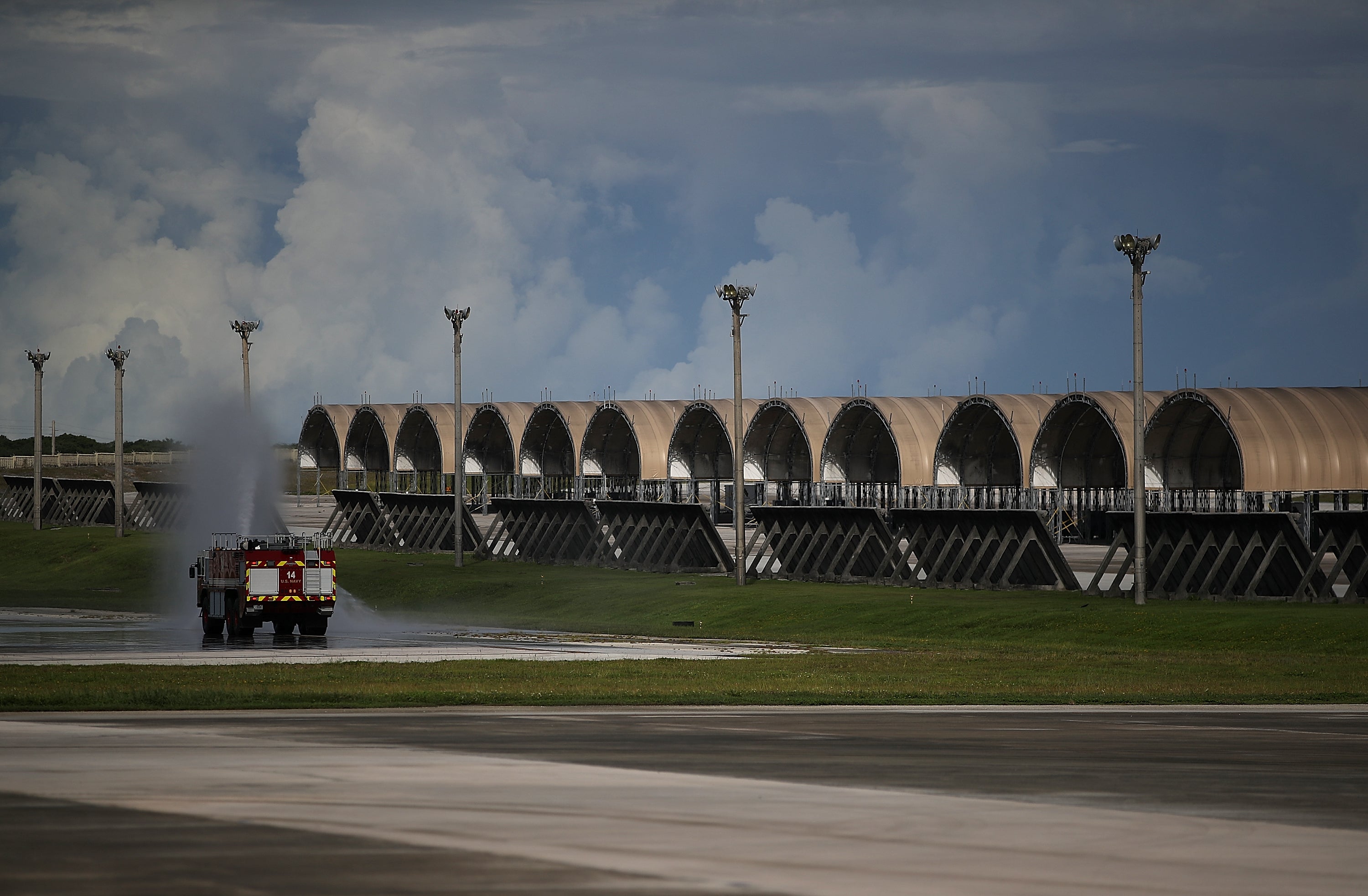 File. US Air Force firtruck sprays water near plane hangars at Andersen Air Force base in Guam