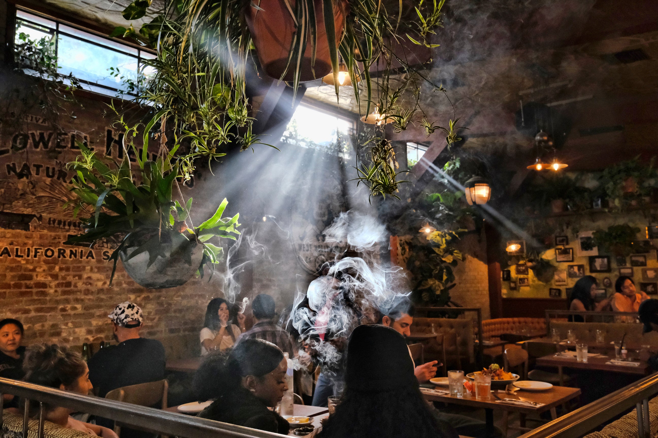 People smoke marijuana at Lowell's Original Cannabis Cafe, a legal marijuana establishment, in Los Angeles