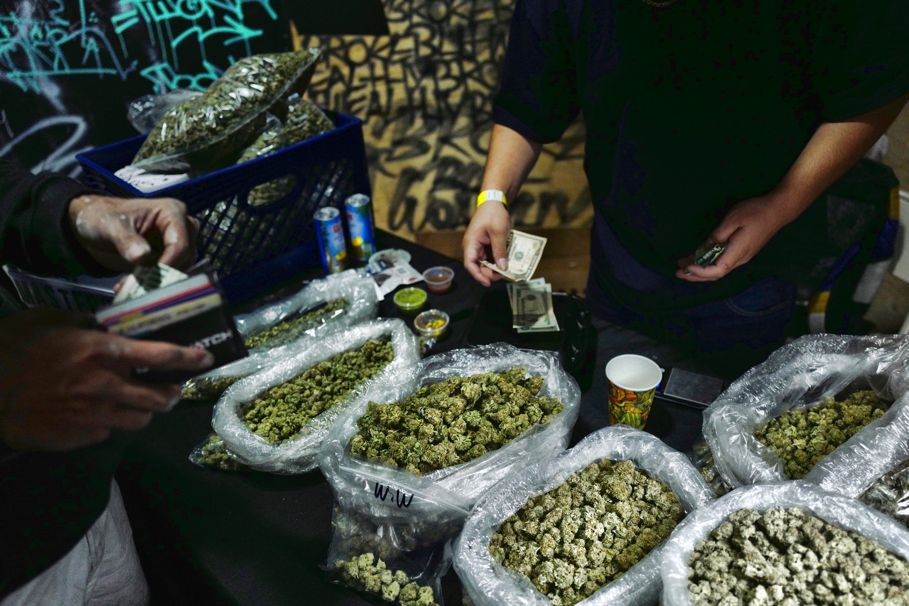 A vendor makes change for a marijuana customer at a cannabis marketplace in Los Angeles,