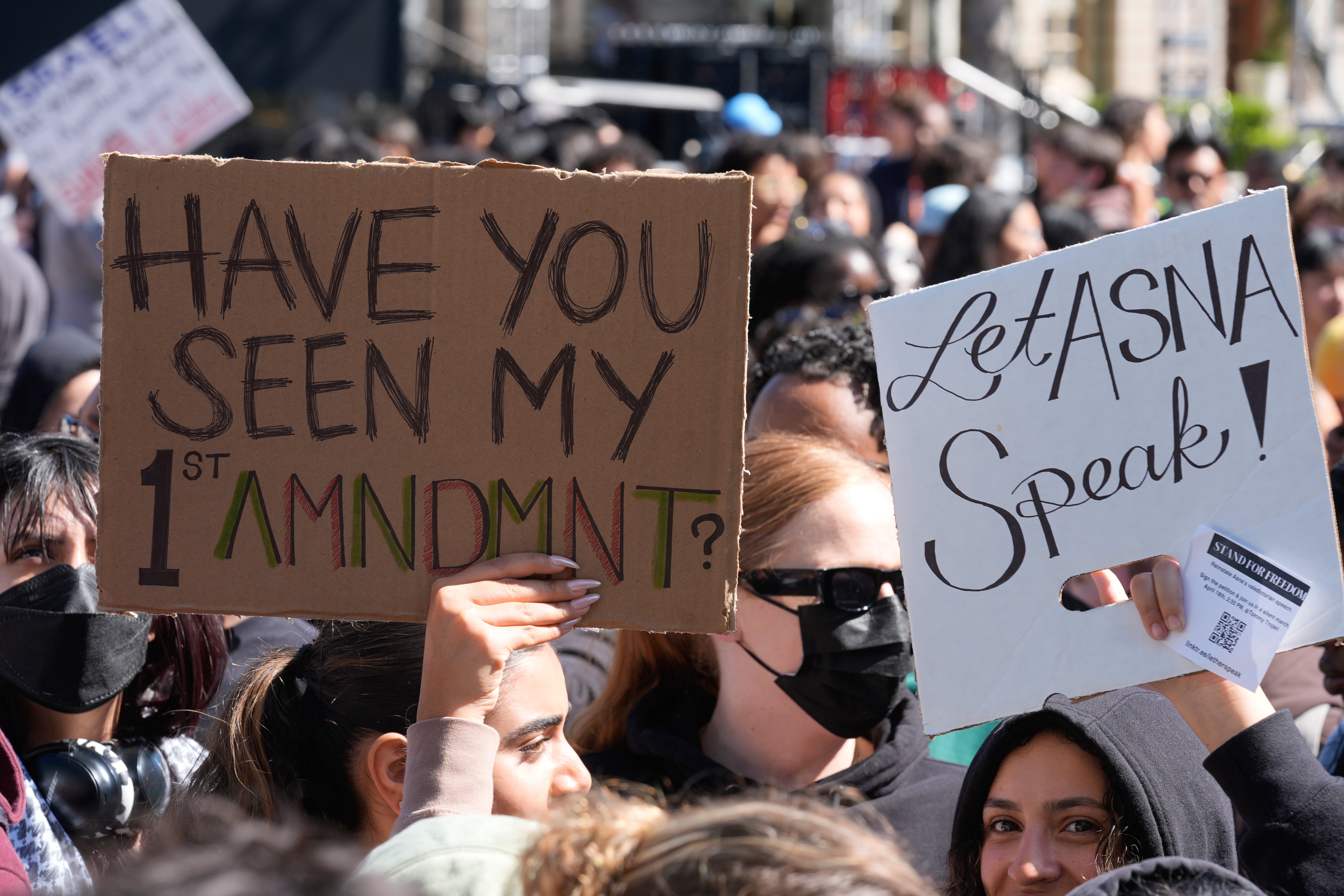 Students carrying signs protest a canceled commencement speech by its 2024 valedictorian