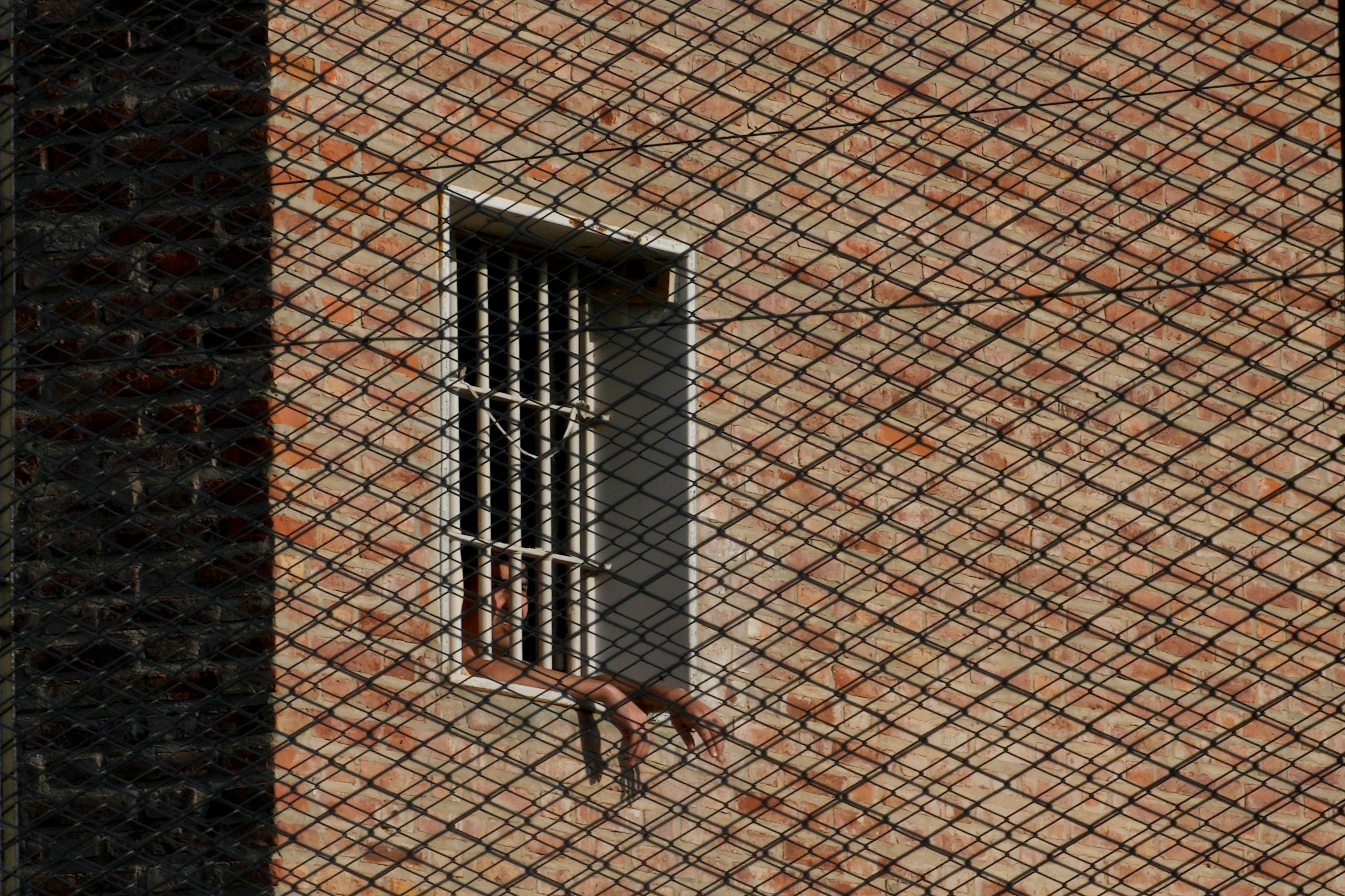 An inmate looks out from a window at Pinero jail in Pinero, Argentina, Tuesday, April 9, 2024