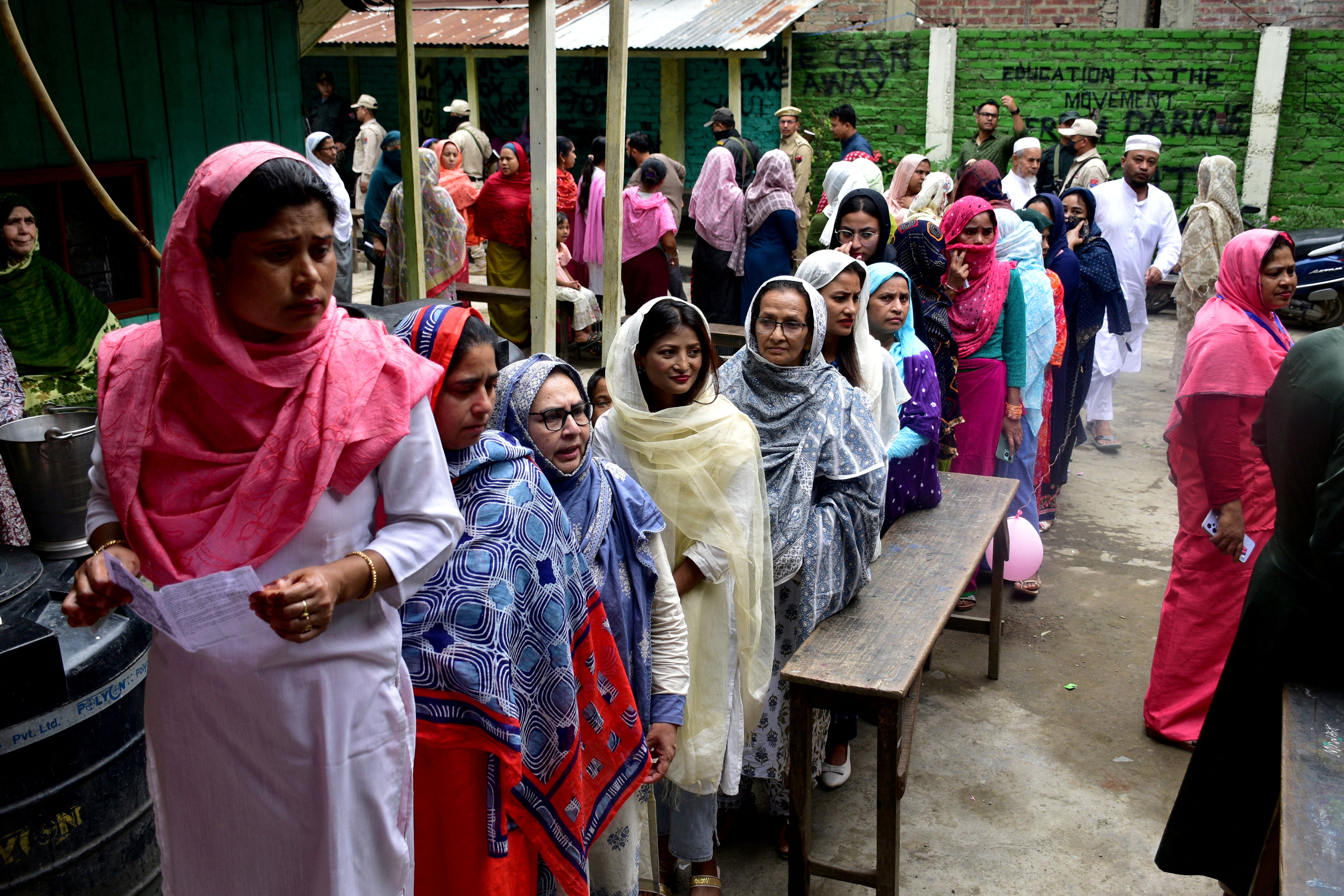 Women wait to cast their votes at a polling station during the first phase of the general election, in Imphal, Manipur