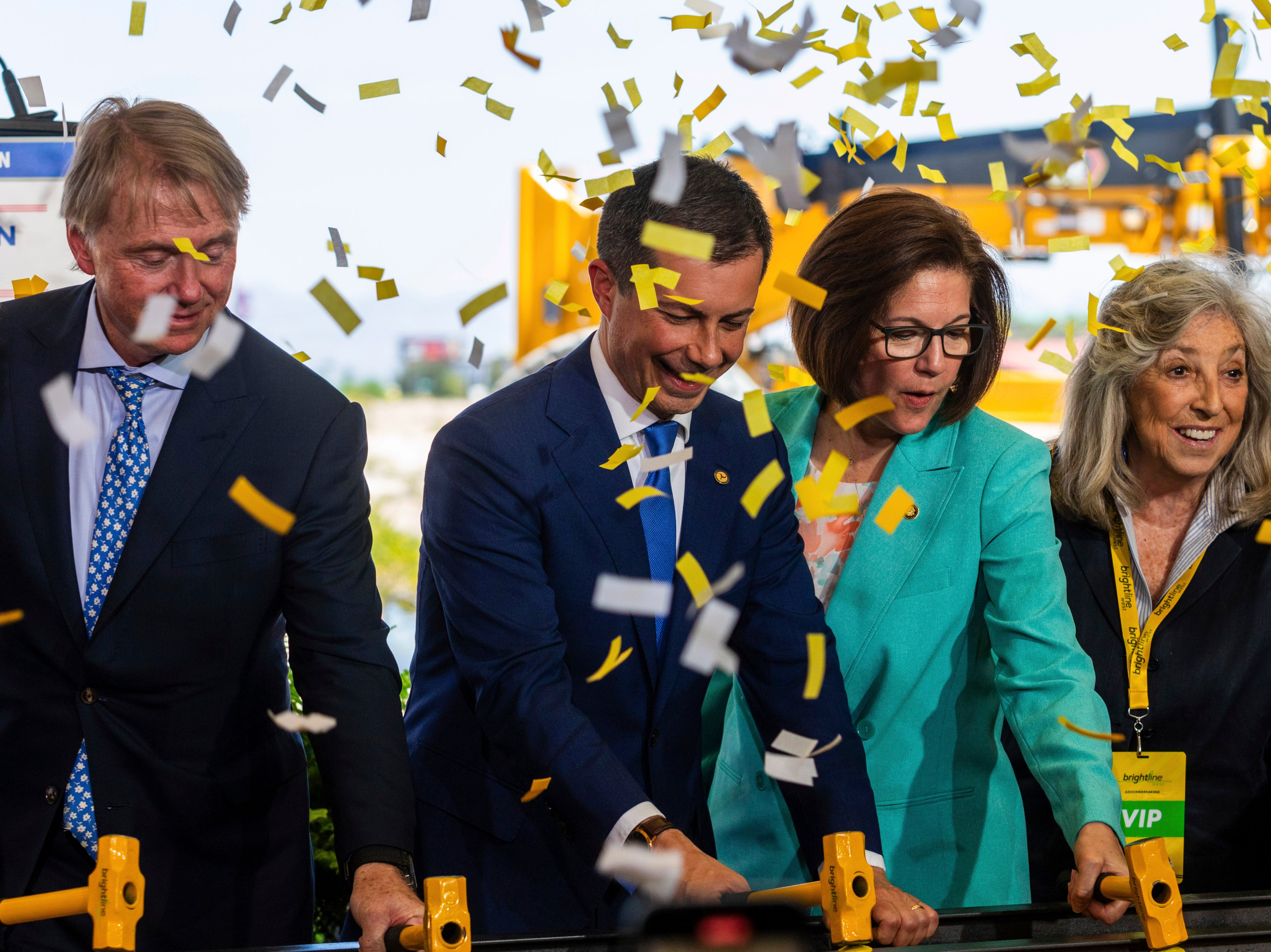 US Secretary of Transportation Pete Buttigieg, center, Senator Catherine Cortez Masto, right, drive rail spikes into a symbolic rail, on Monday, April 22, 2024, in Las Vegas