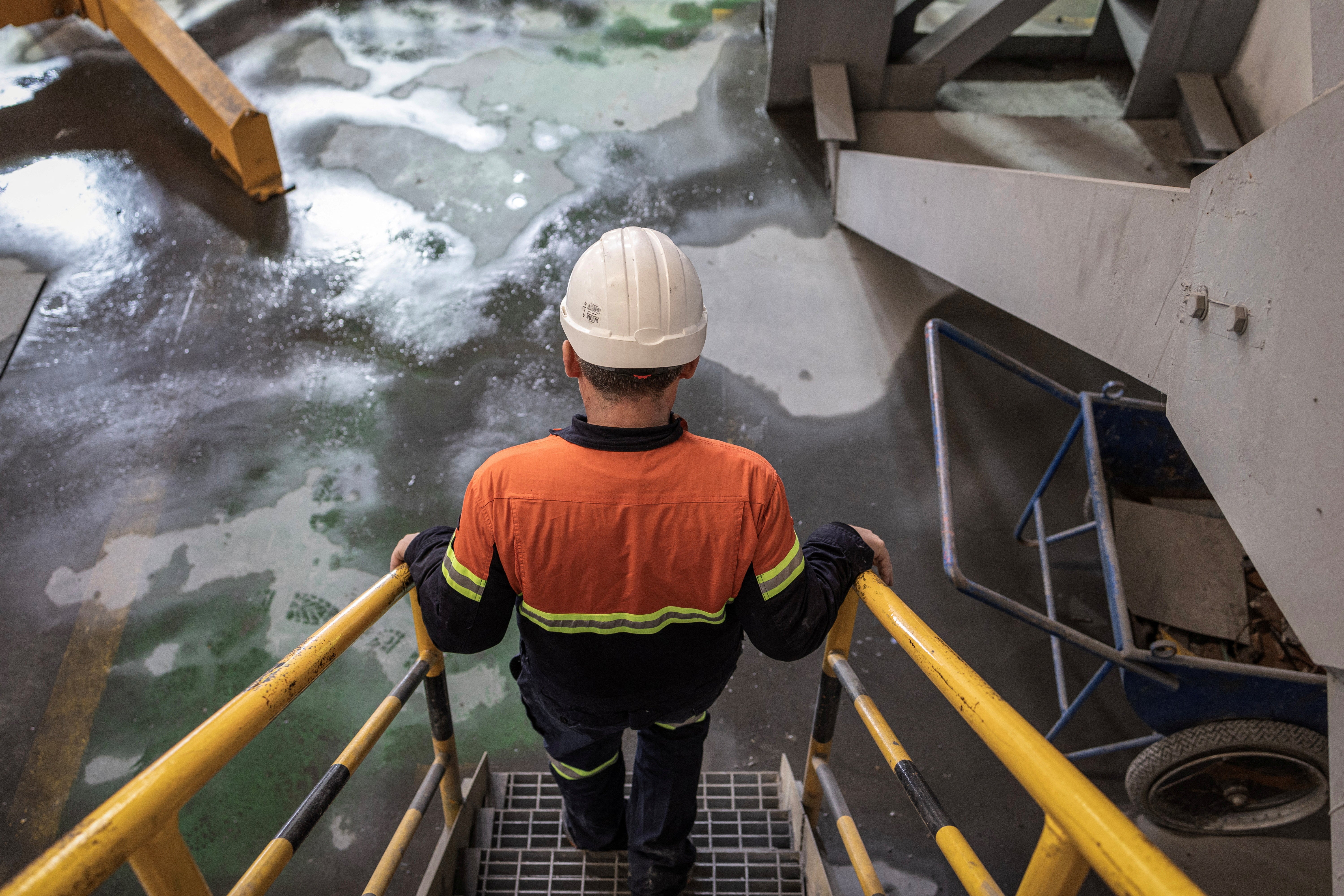 A worker walks down the stairs inside the mill facility of a copper mine