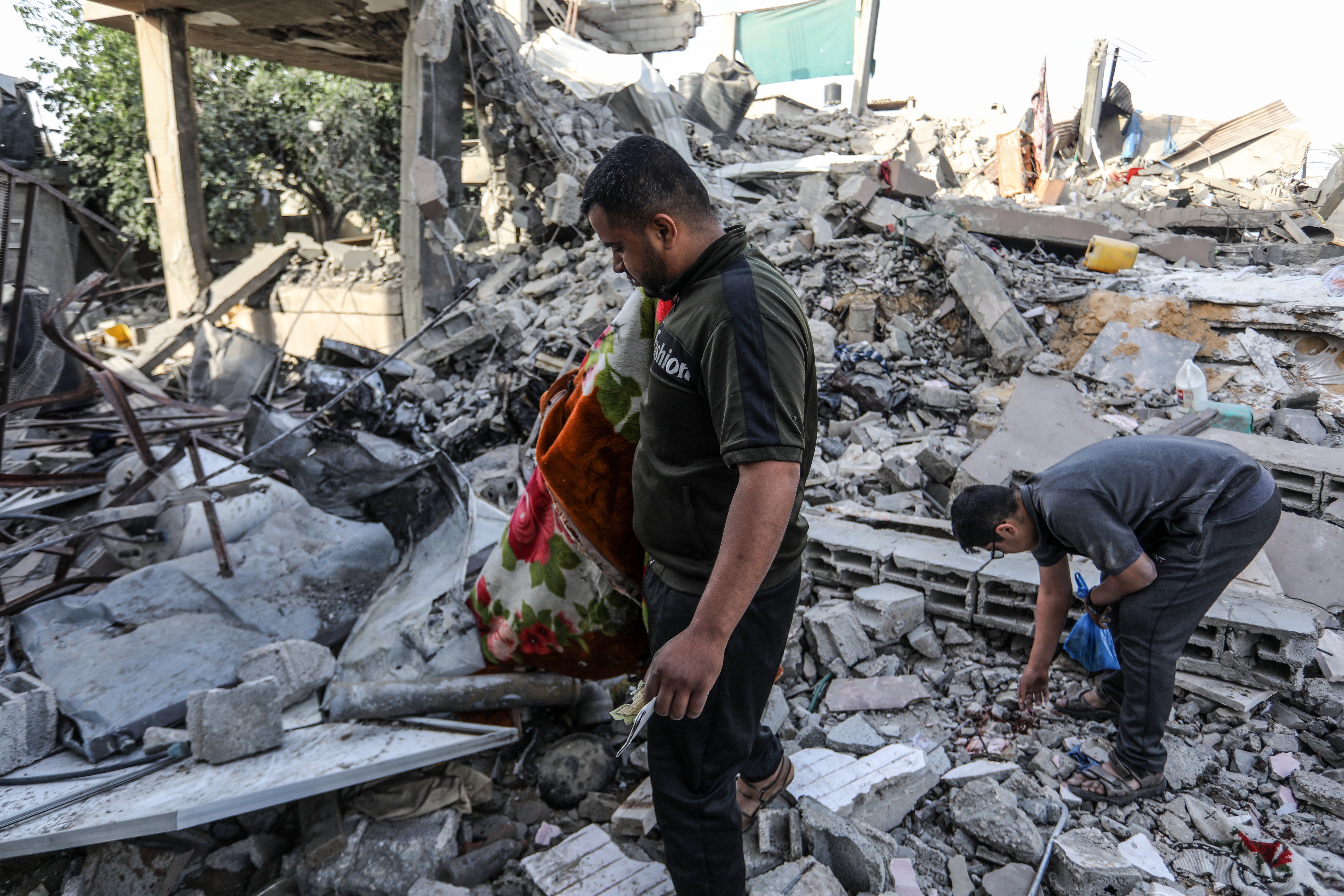 Palestinians inspect demolished buildings after Israeli attacks in Rafah