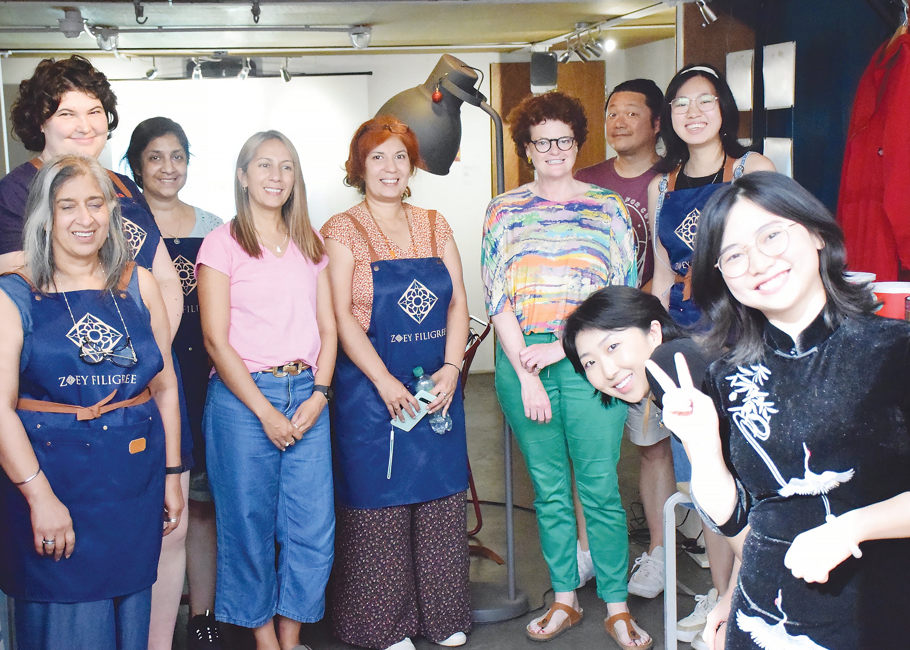 Zou Xuewen (right) poses for a photo with participants at a workshop on Chinese jewellery techniques in London in 2023