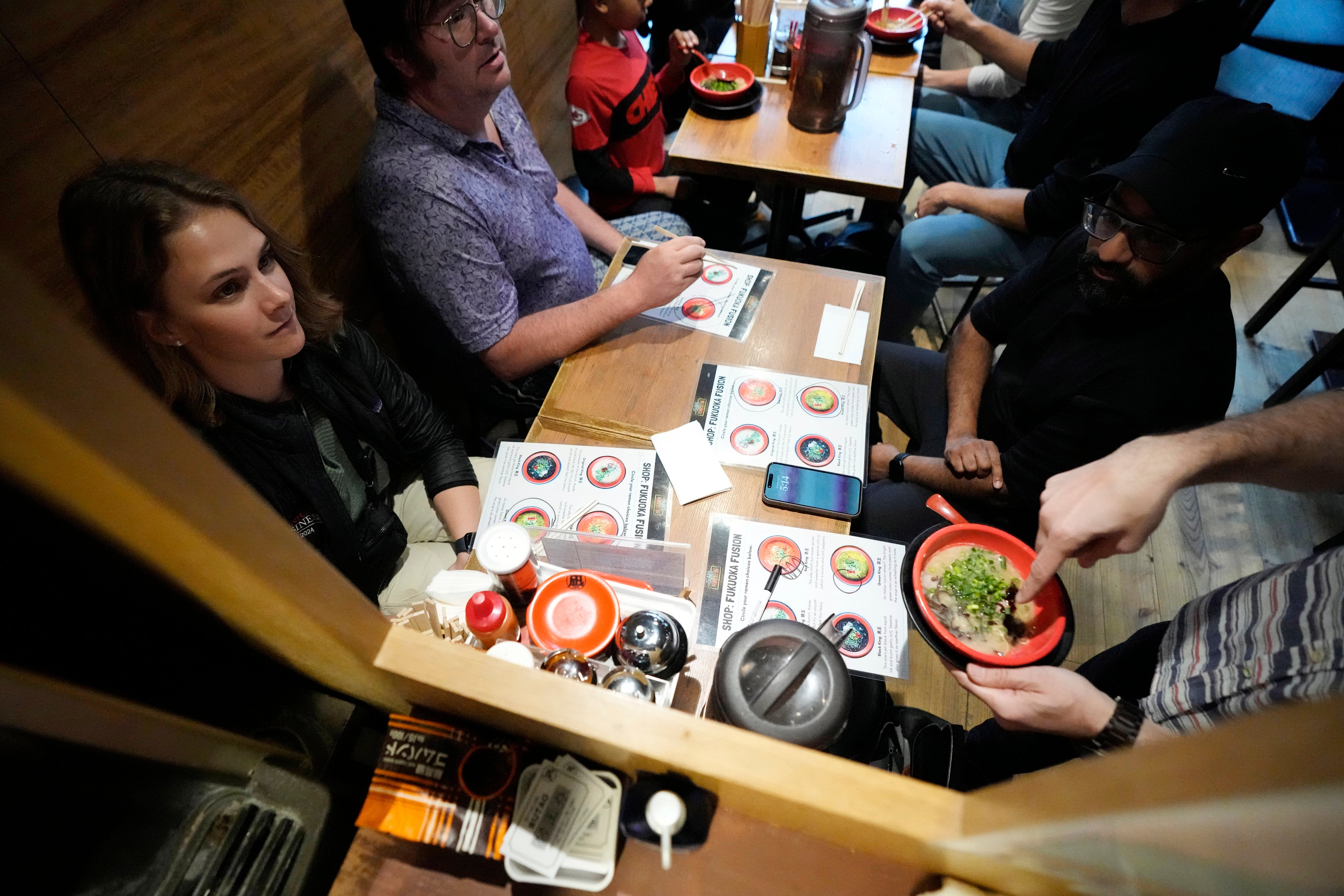 Frank Striegl, bottom right, a guide of Tokyo Ramen Tours, explains participants of a ramen tasting tour at Nagi