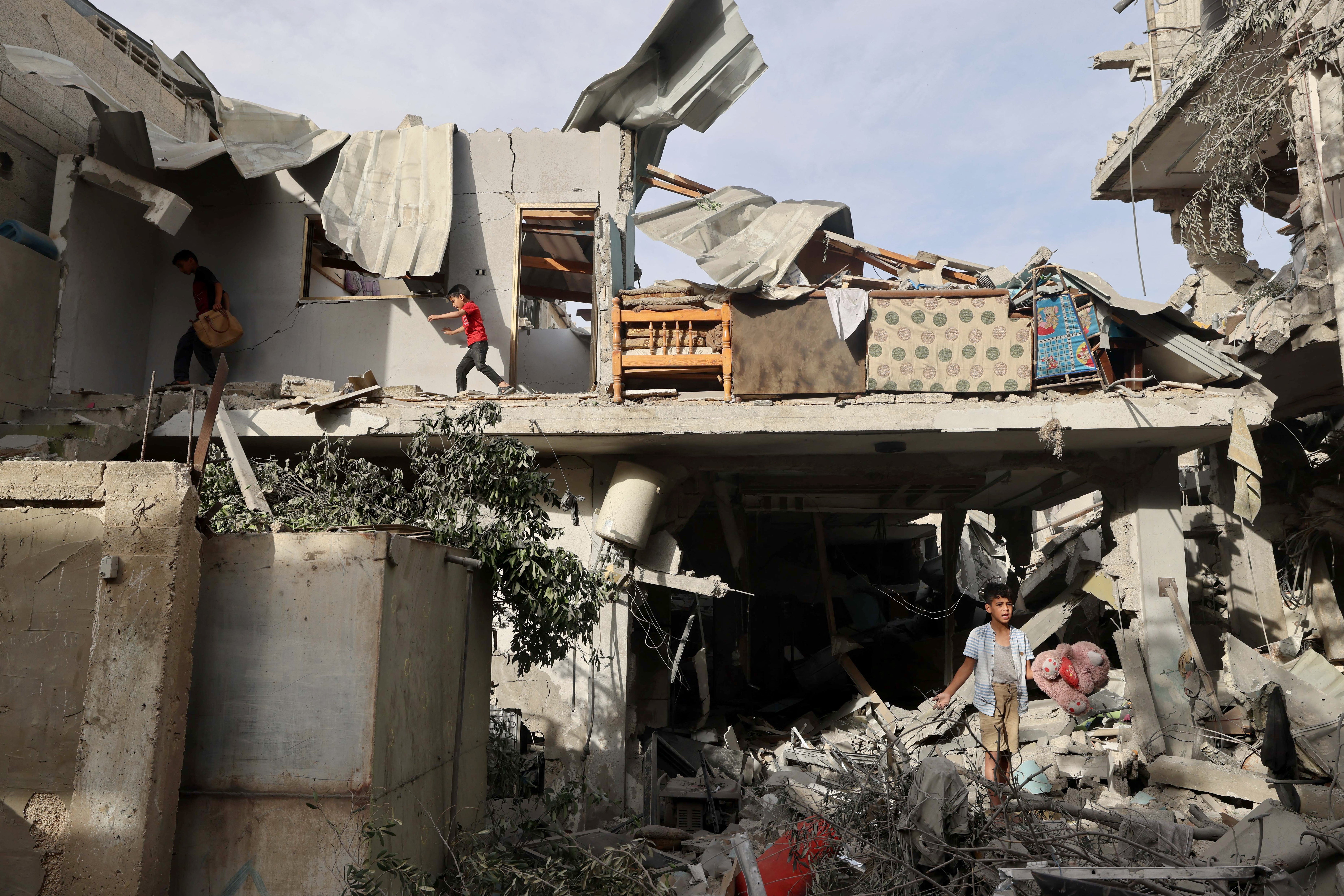 Palestinian youths search the rubble of a building hit in overnight Israeli bombardment in Rafah in the southern Gaza Strip