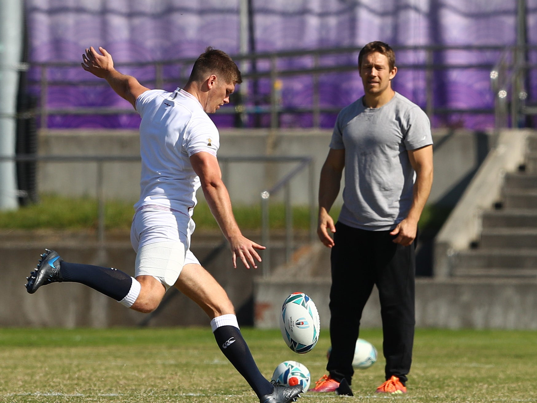 Ex England player Jonny Wilkinson looks on as Owen Farrell practises drop goals in Tokyo in 2019