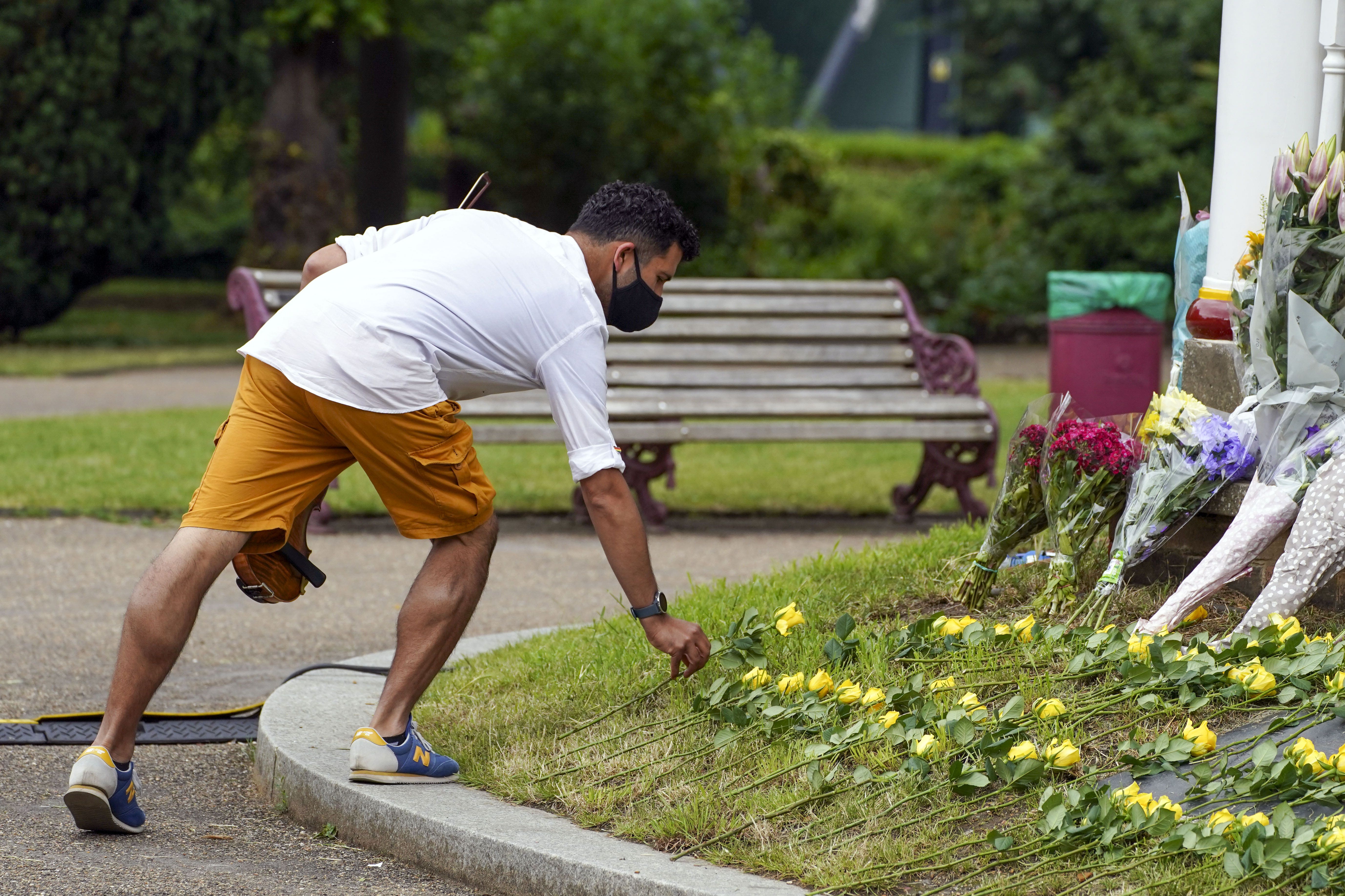 People lay a single yellow rose during a memorial service at Forbury Gardens bandstand in Reading to mark the one year anniversary of the terror attack (Steve Parsons/PA)