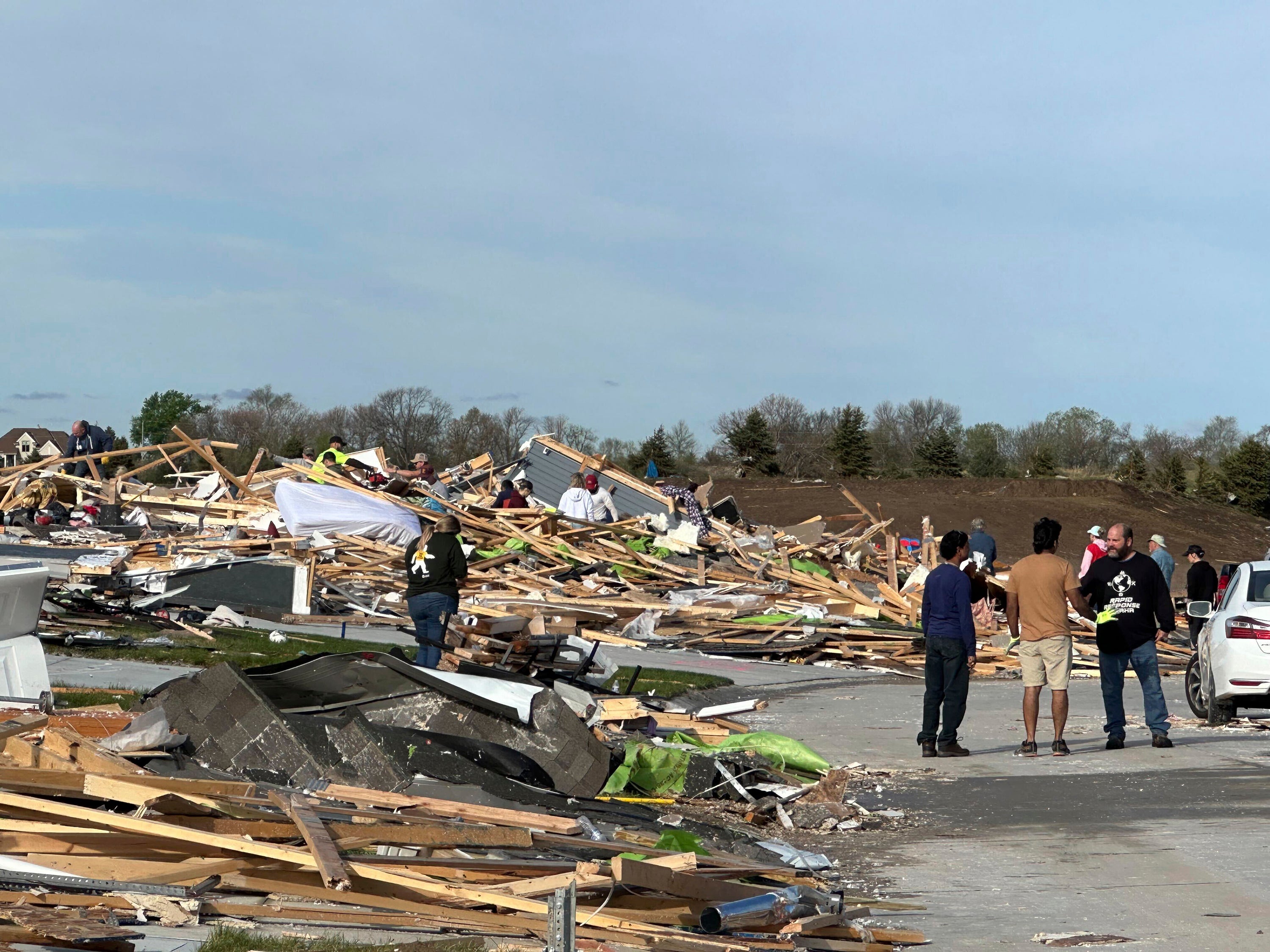 People are pick through the rubble of a house that was leveled in Elkhorn, Neb., on Saturday, April 27, 2024.