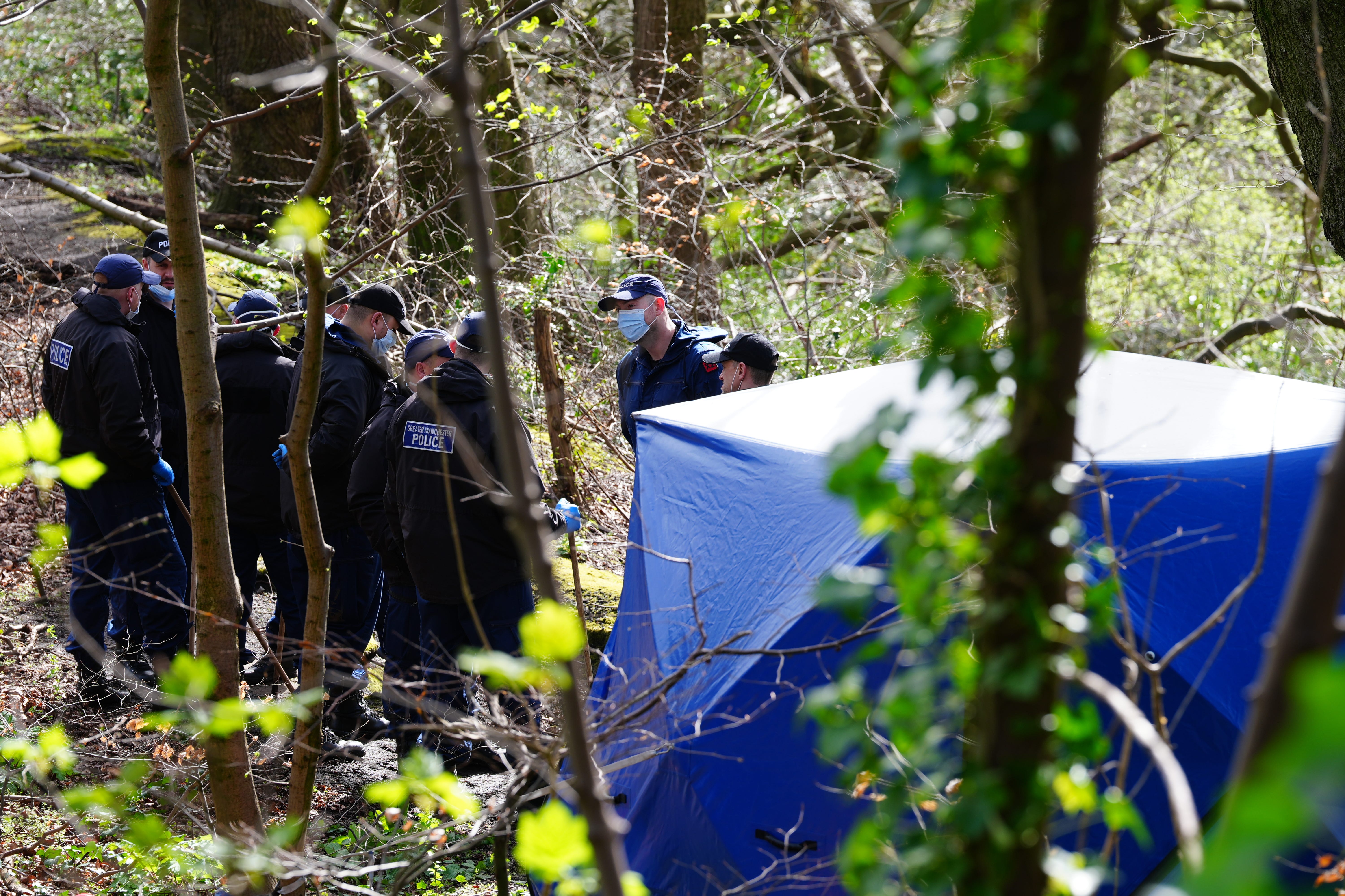 Police officers by a forensic tent at Kersal Dale