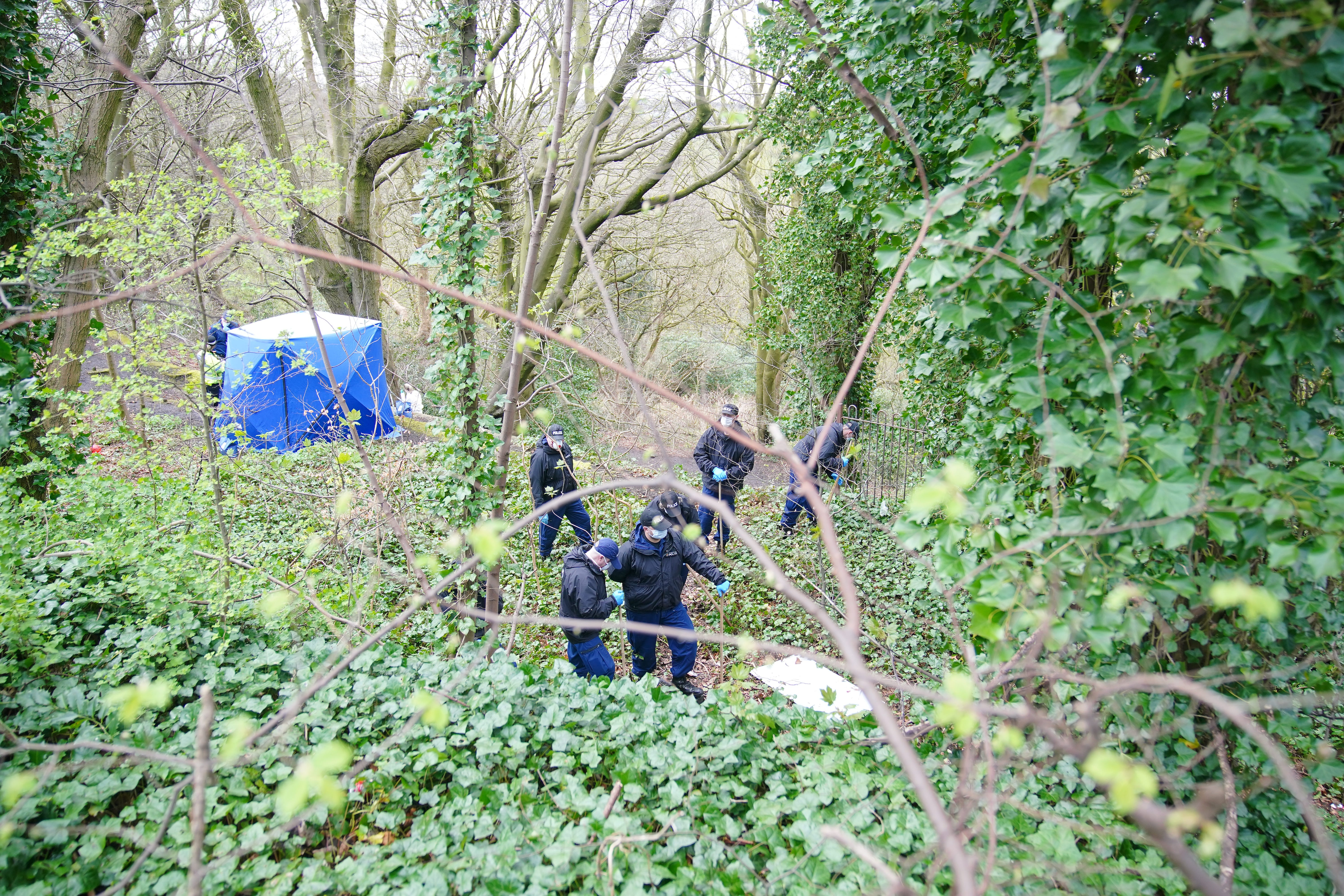 Police officers search by a forensic tent at Kersal Dale, near Salford, Greater Manchester (Peter Byrne/PA)