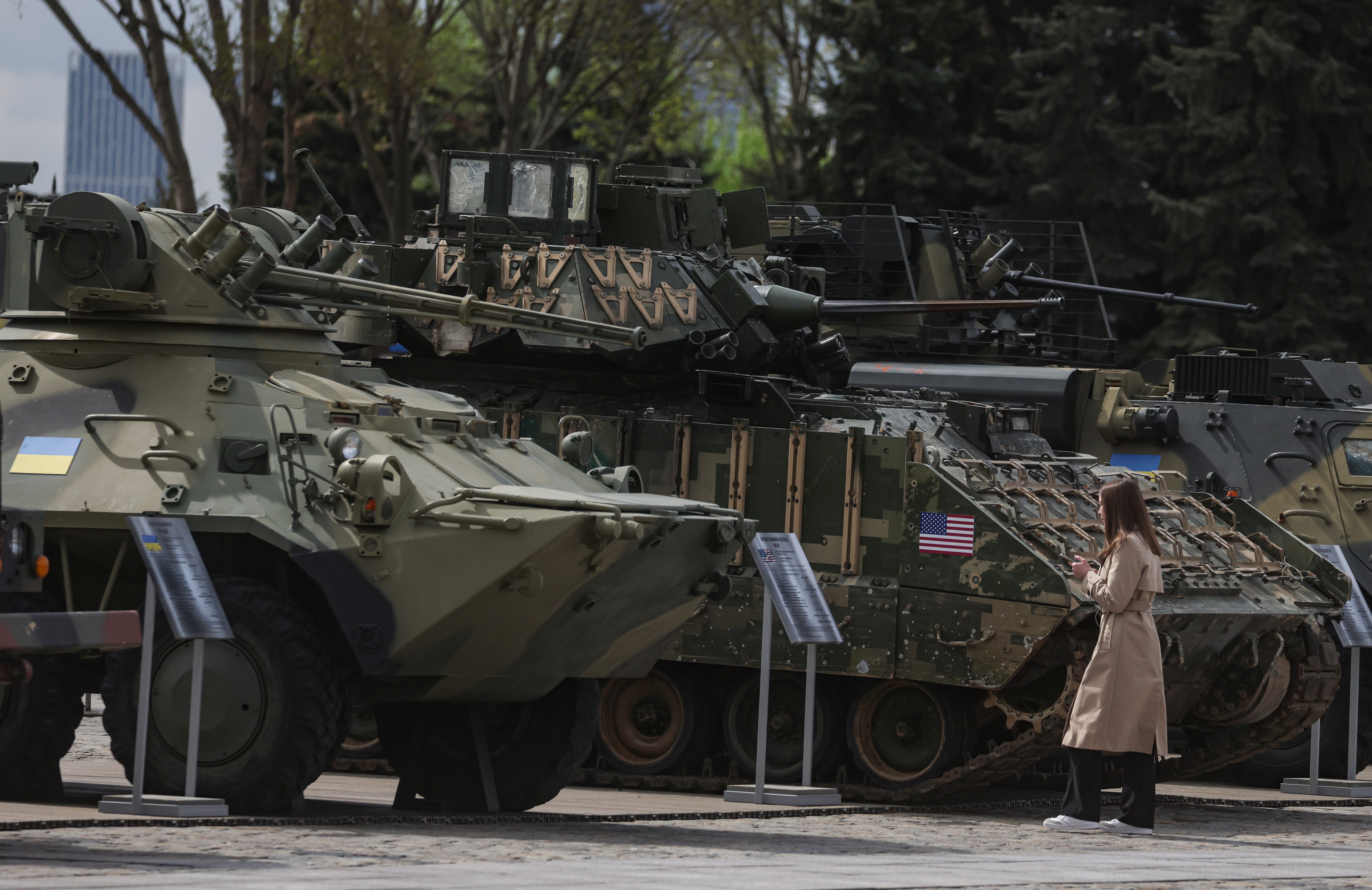 A woman examines armoured vehicles captured by Russian troops during the war in Ukraine during an exhibition on the Poklonnaya Hill