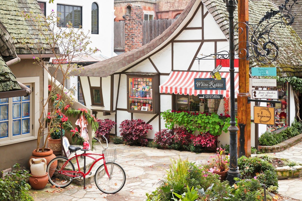 A streetscape in Carmel-by-the-Sea featuring a retail shop housed in a typical fairytale cottage - style architecture. Carmel located on the Monterey Peninsula was founded in 1902 and is known for its natural scenery and artistic history