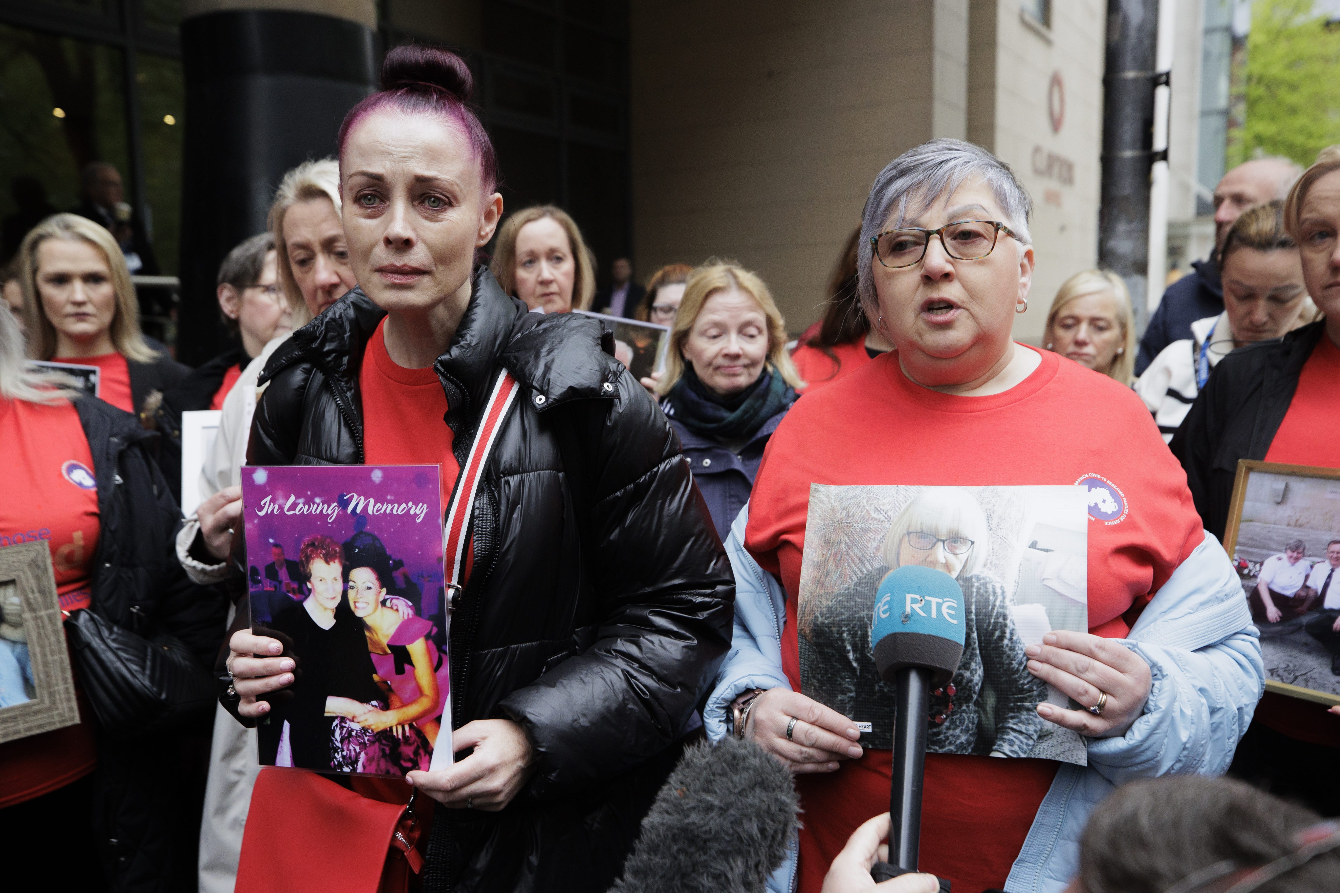 Relatives of local people who died during the pandemic wore red and held pictures of their loved ones outside the inquiry venue (Liam McBurney/PA)