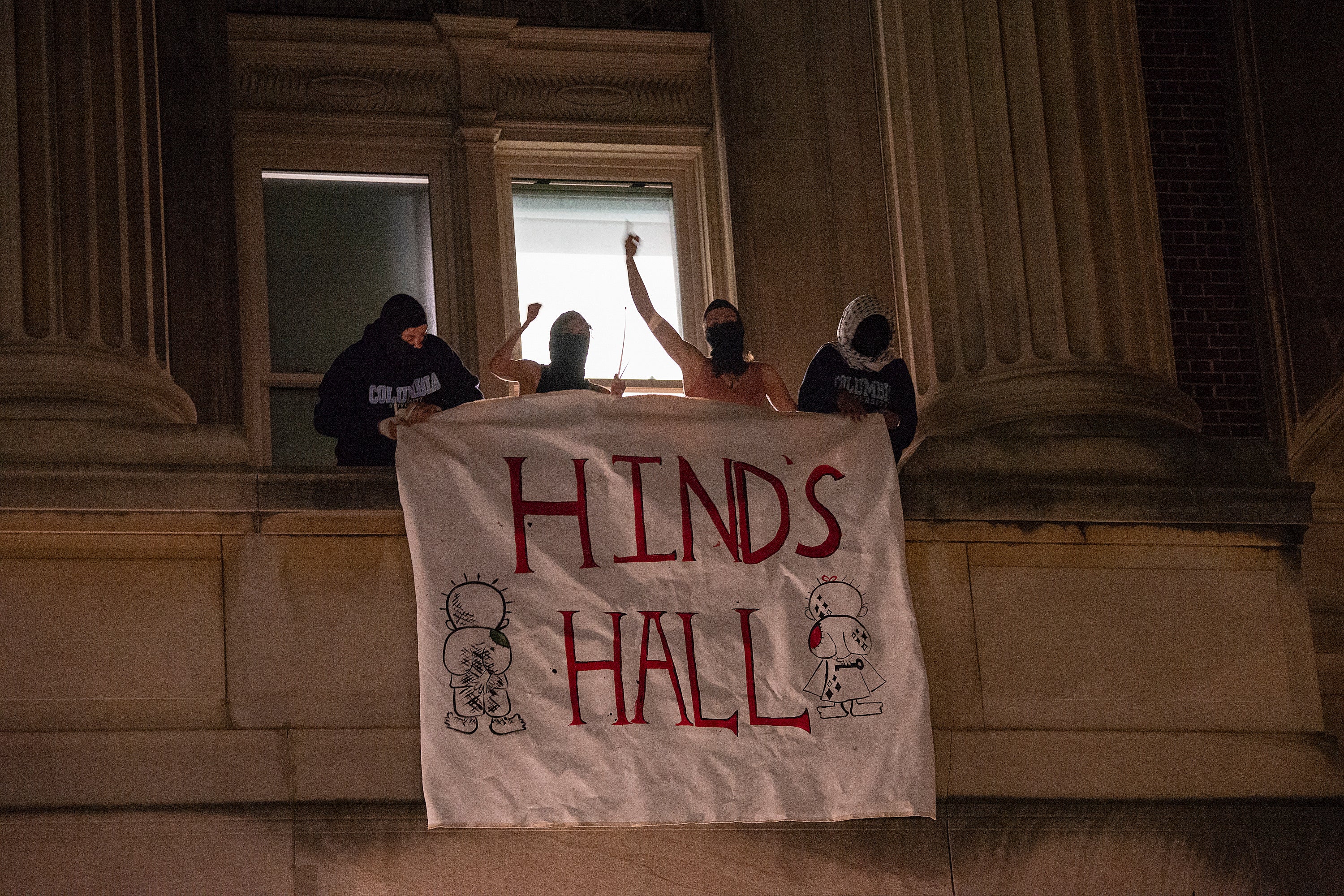 Students fly a banner that reads “Hind’s Hall” out of a Hamilton Hall window on Columbia University’s campus. Dozens of occupiers were arrested, however, the Manhattan DA has dropped charges against 31 of them