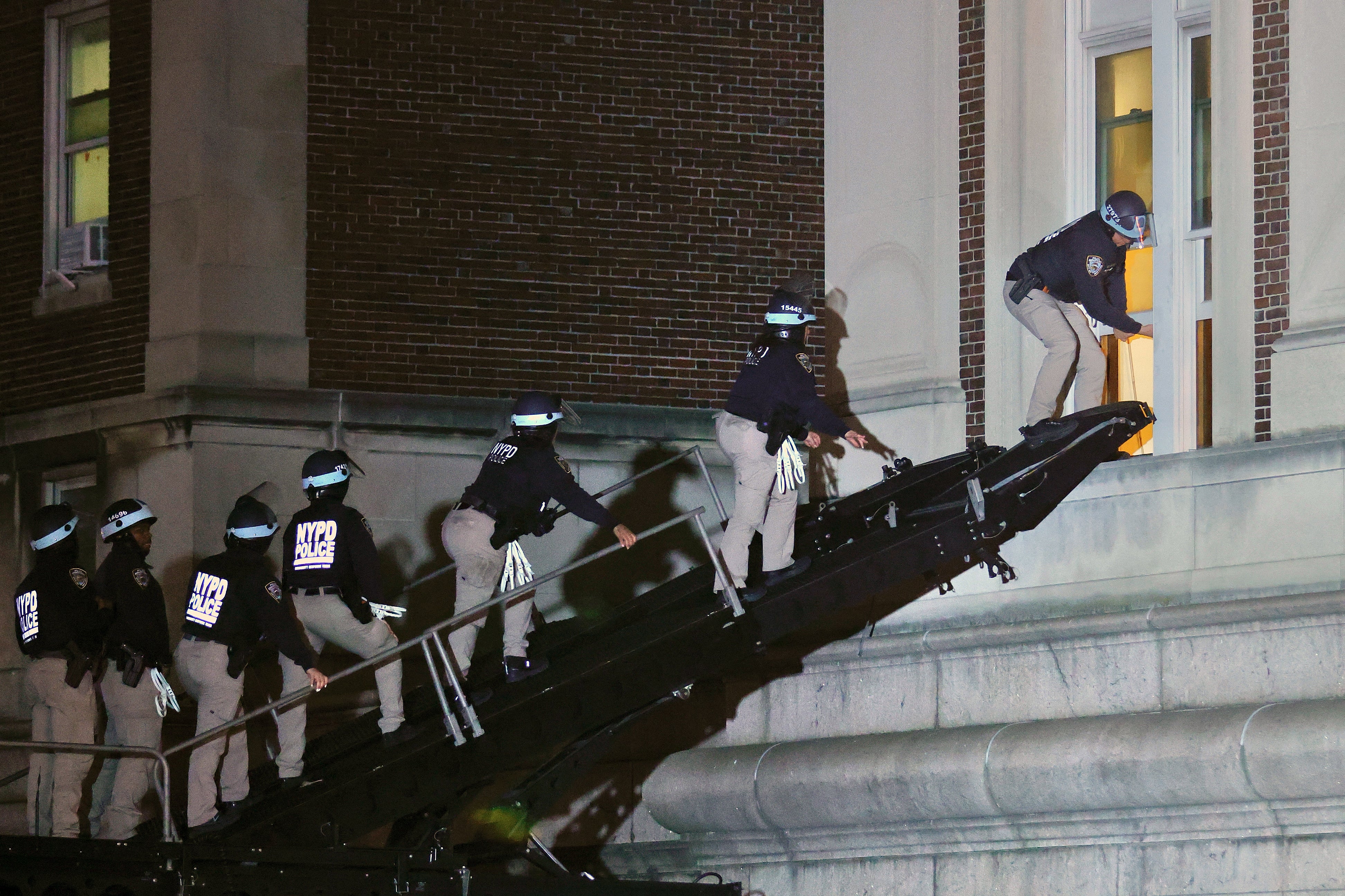 NYPD officers in riot gear break into a Columbia University building where pro-Palestinian students were barricaded inside on 30 April.