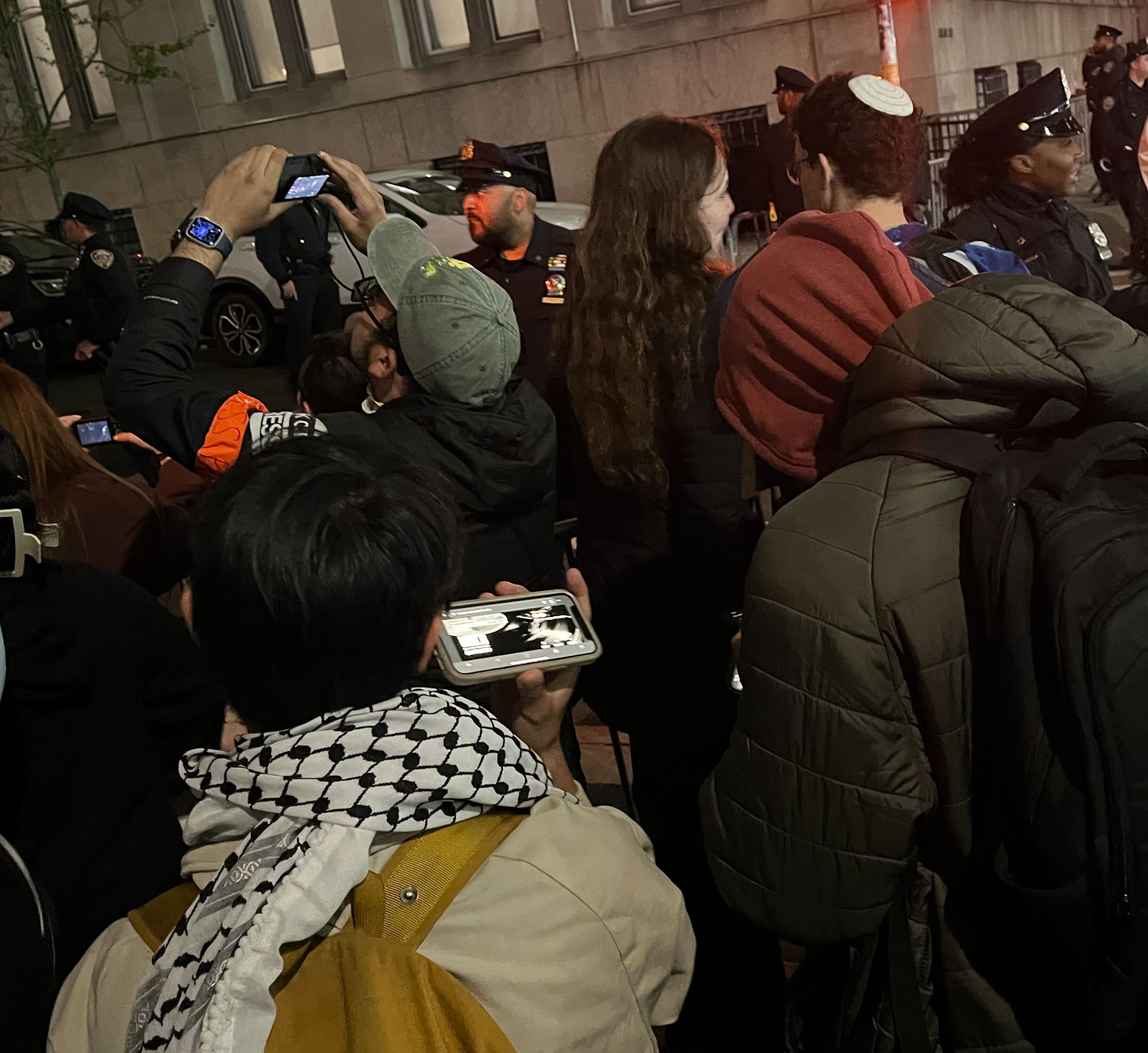 A protester at Columbia University listens to a WKCR live stream as NYPD enter campus on 30 April.