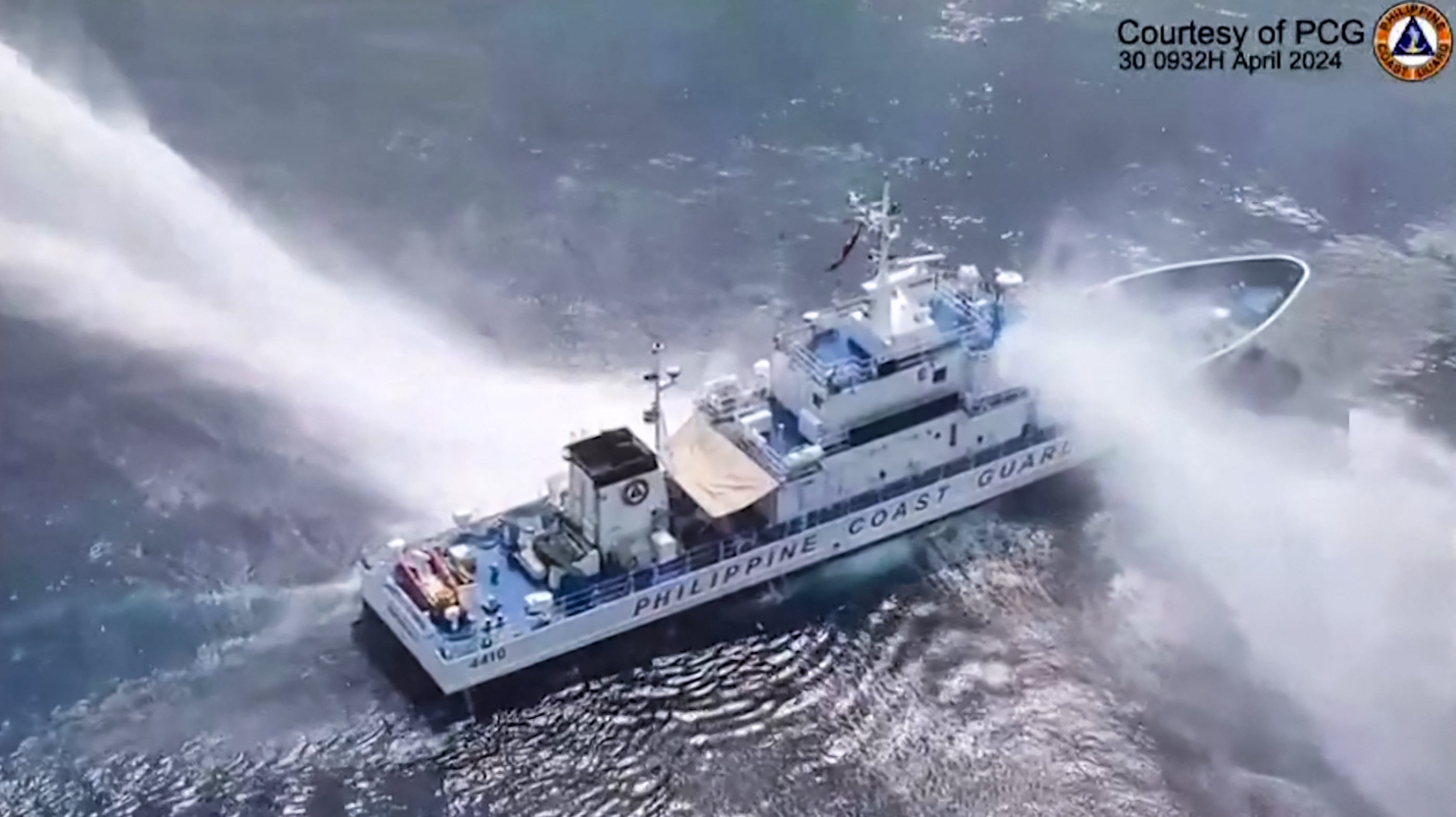 This frame grab from handout video footage taken and released on April 30, 2024 by the Philippine Coast Guard (PCG) shows the Philippine Coast Guard ship BRP Bagacay being hit by water cannon from Chinese coast guard vessels near the chinese-controlled Scarborough shoal in disputed waters of the South China Sea