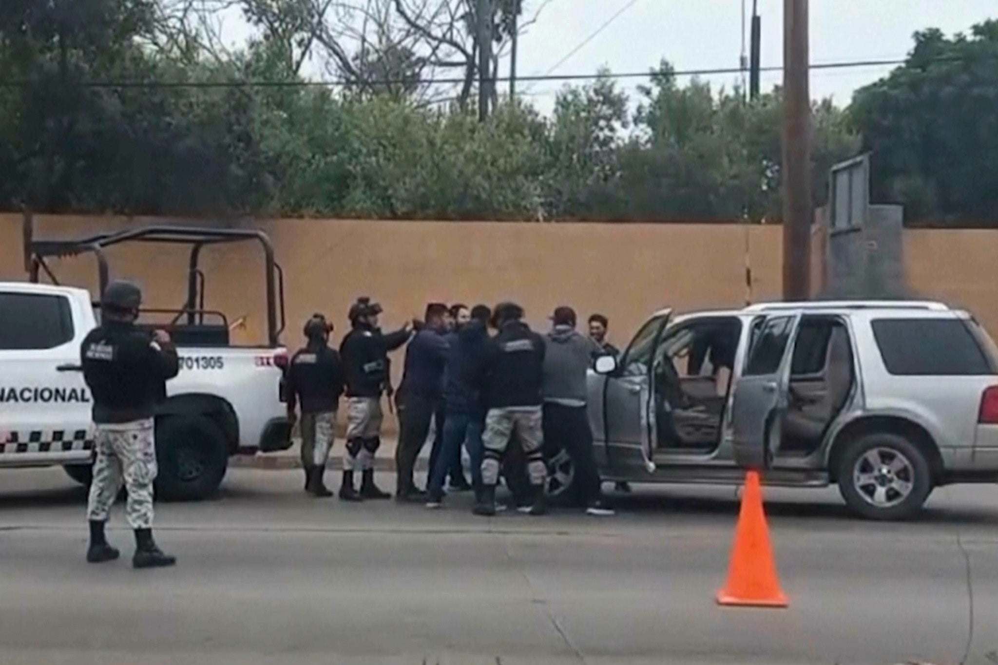 Mexican security forces frisk men at a checkpoint in Ensenada on 2 May 2024. Mexican authorities said Thursday they have found tents and questioned a few people in the case of two Australians and an American who went missing over the weekend in the Pacific coast state of Baja California