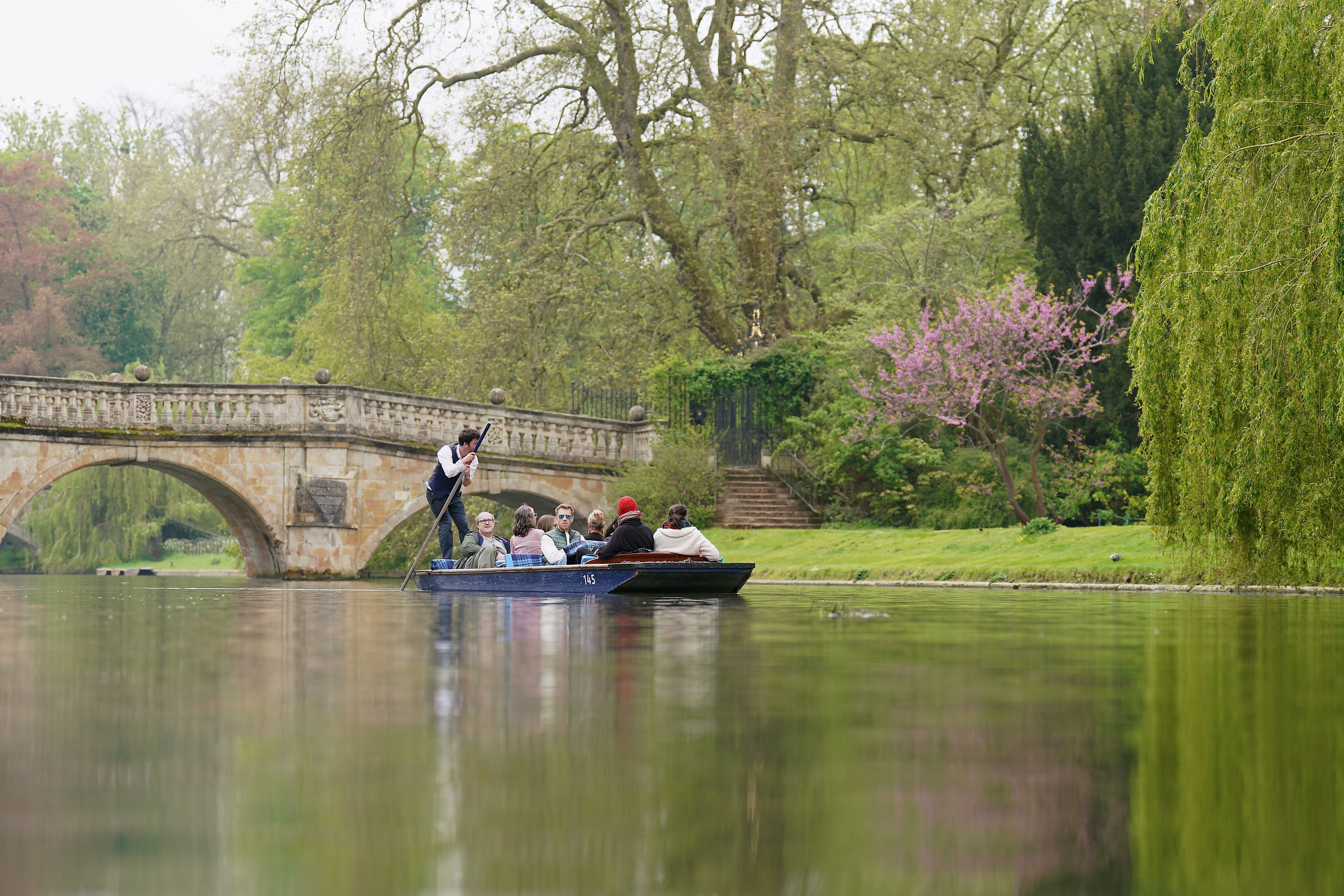 People enjoy a punt tour along the River Cam in Cambridge (PA)