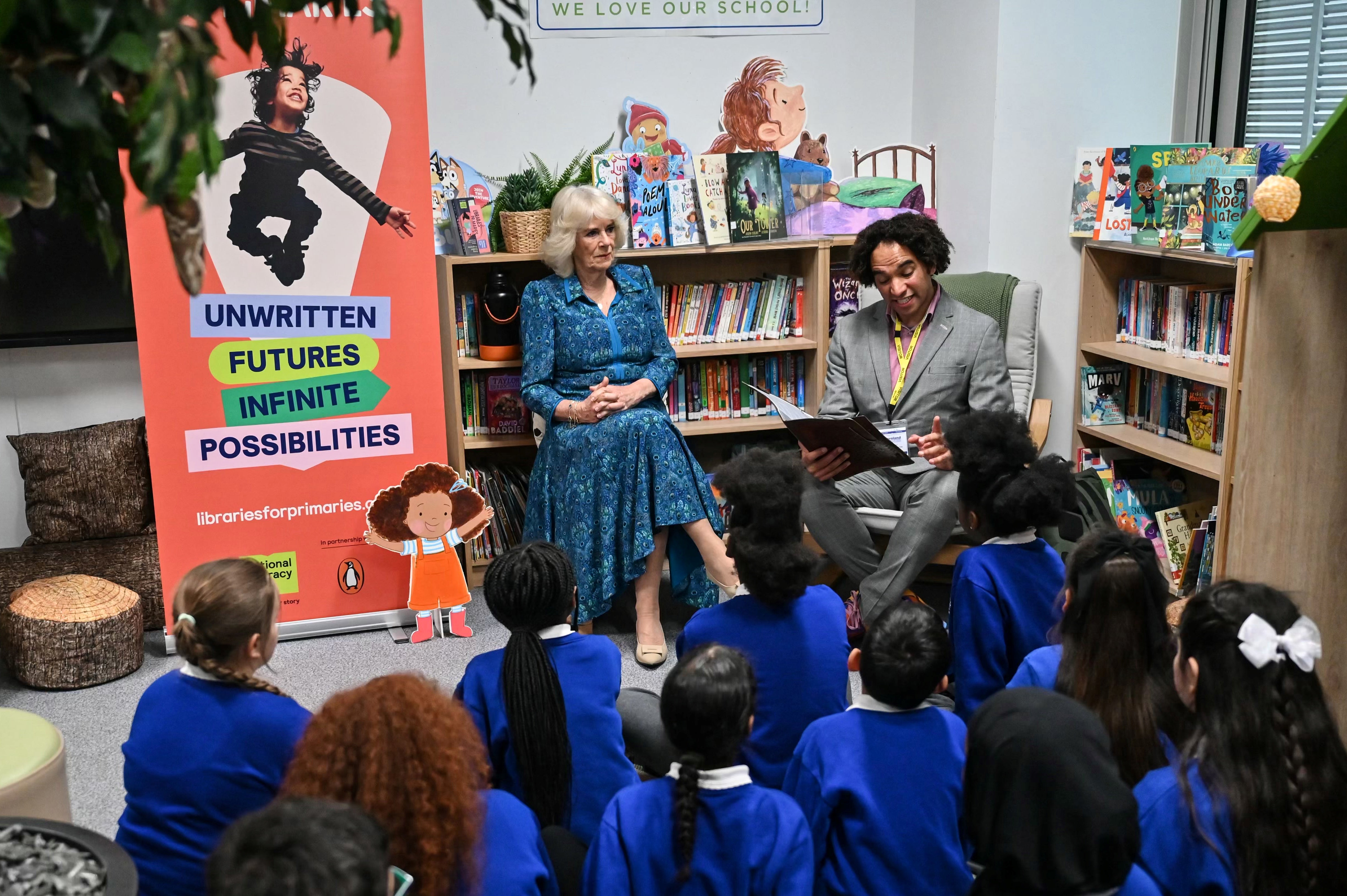 Queen Camilla and pupils listen to Waterstones Children's Laureate and poet Joseph Coelho reading a poem in the library