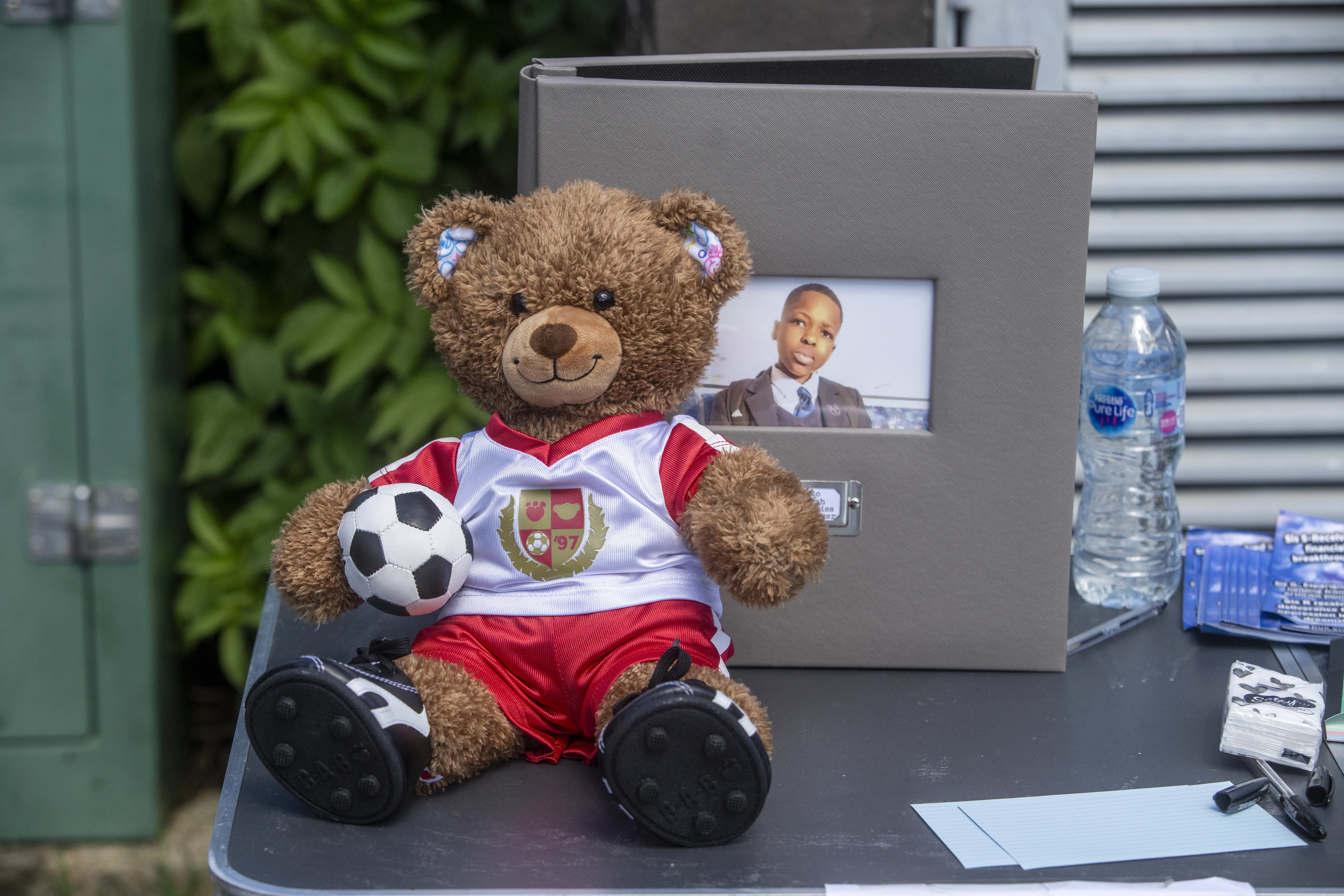 A teddy bear in an Arsenal top on a table at vigil in Hainault (Jeff Moore/PA)