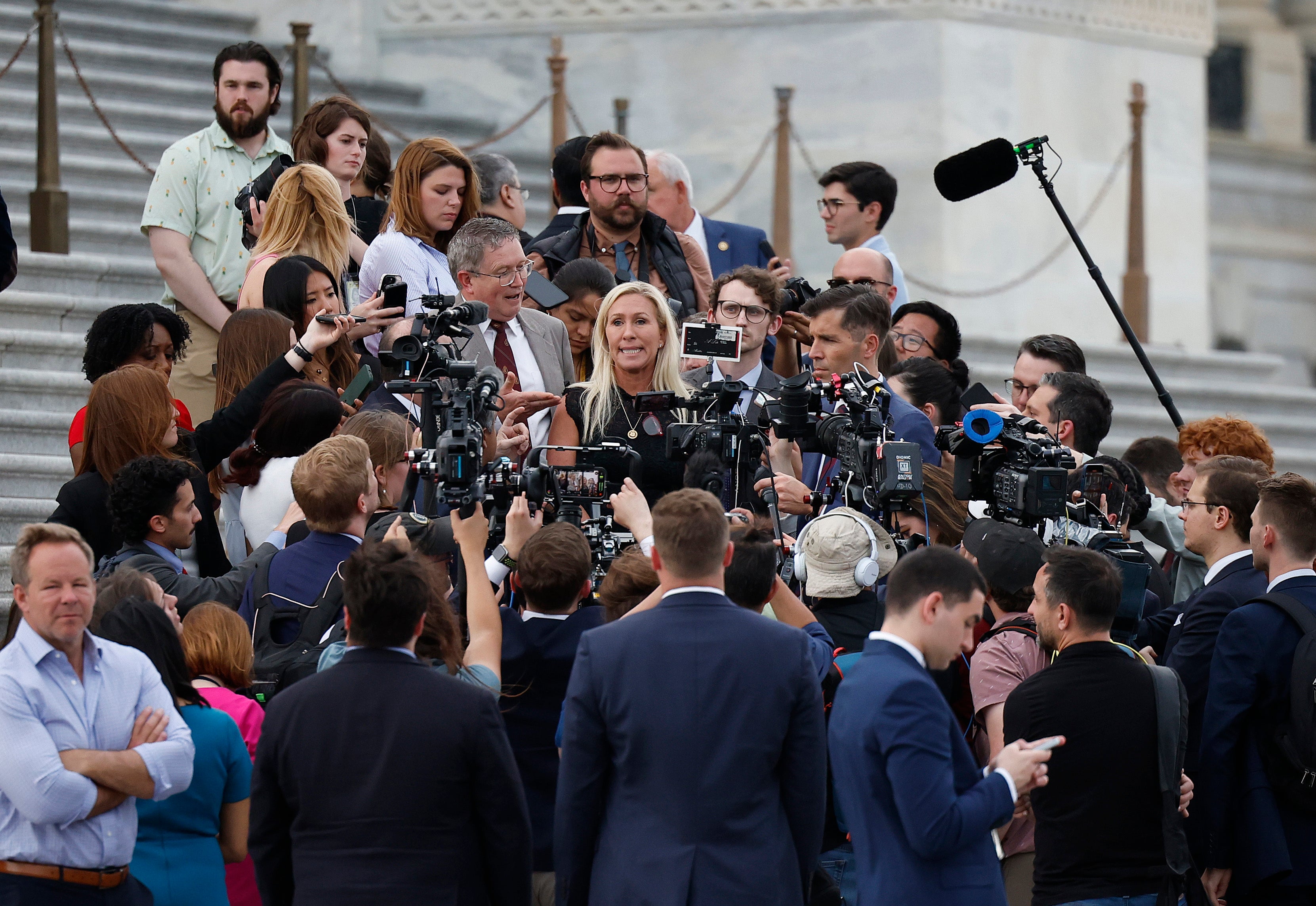 WASHINGTON, DC - MAY 08: U.S. Rep. Marjorie Taylor Greene (R-GA), trailed by Rep. Thomas Massie (R-KY), speaks to members of the press while exiting the U.S. Capitol after introducing a motion to vacate on the floor of the House of Representatives seeking to remove Speaker of the House Mike Johnson (R-LA) from his leadership position May 8, 2024 in Washington, DC. The House voted 359 to 43 to table the motion to vacate. (Photo by Kevin Dietsch/Getty Images)