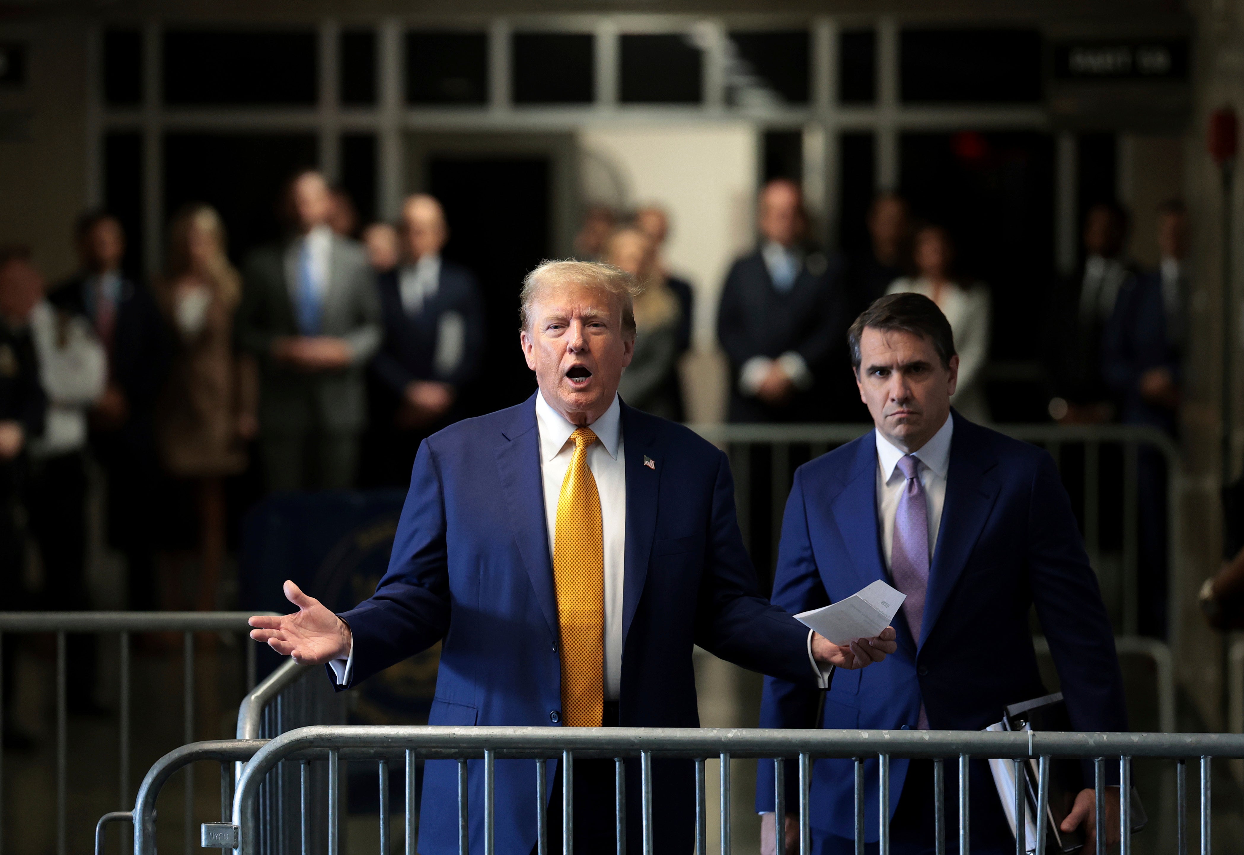 Trump speaks to reporters outside the courtroom on Tuesday 7 May, flanked by his attorney Todd Blanche