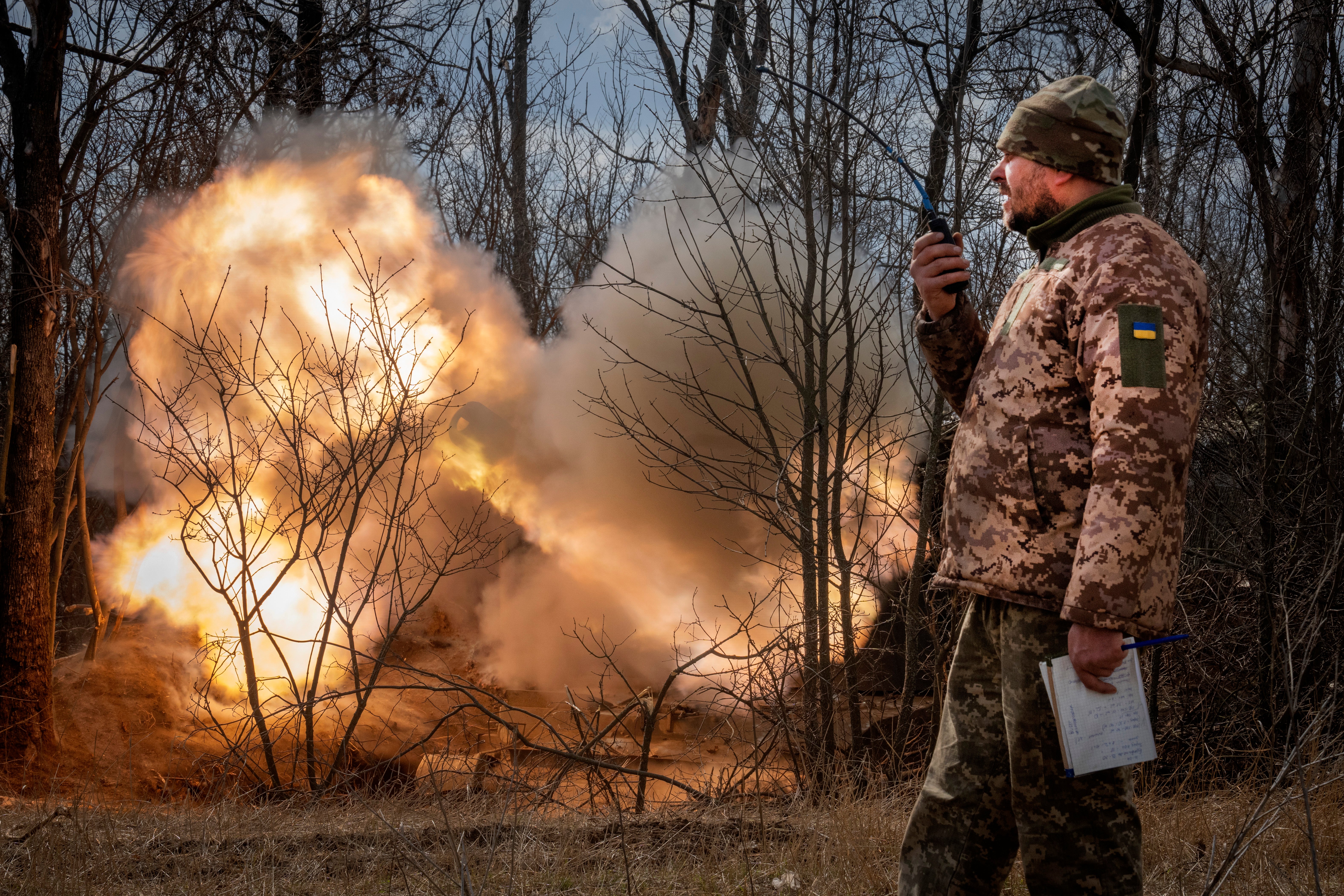 A Ukrainian officer observes the firing of a 152-mm Self-Propelled Howitzer 2S3, towards Russian positions at the frontline