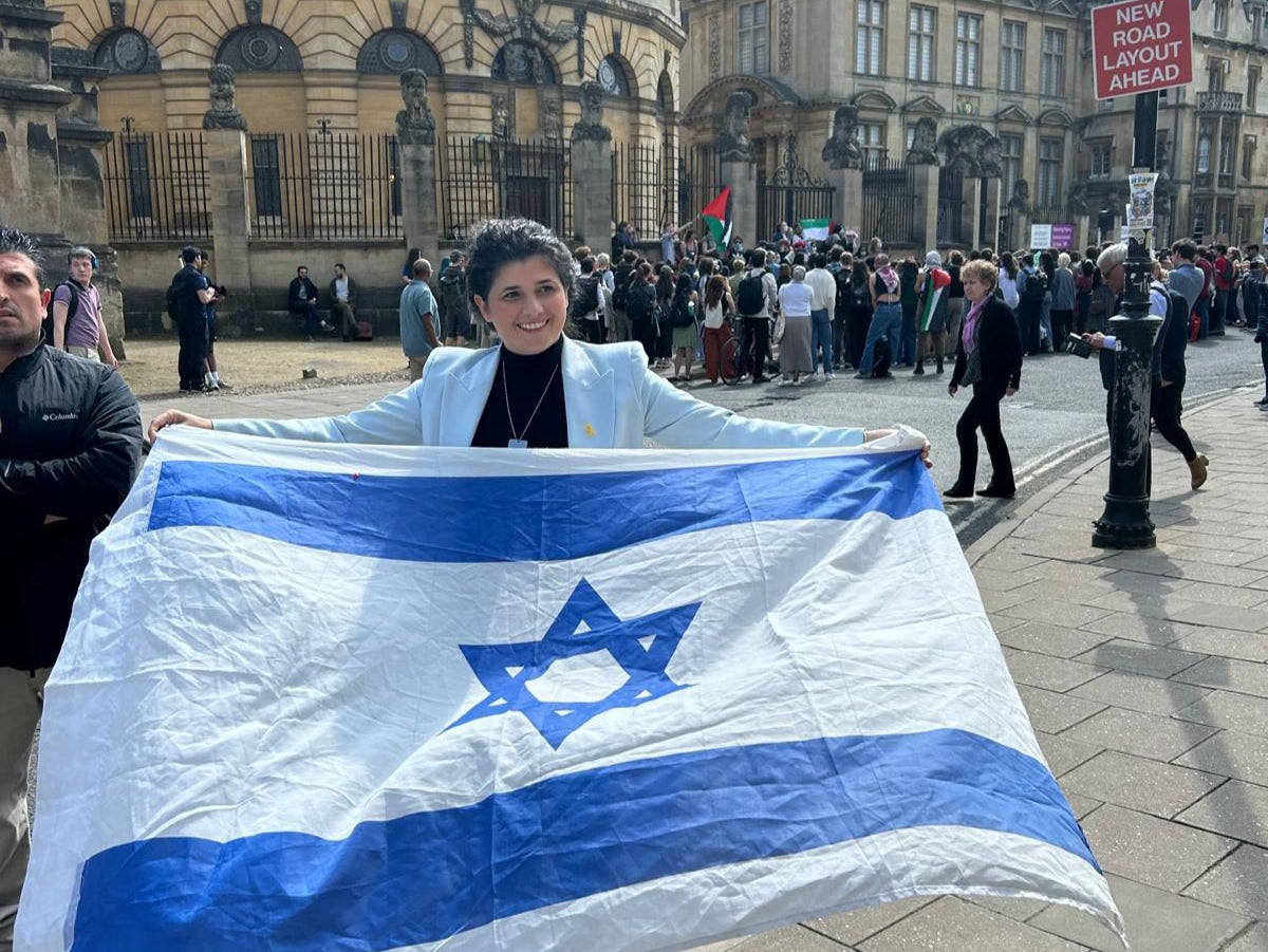 Sharren Haskel unfurls an Israeli flag at a demonstration by students of Oxford University earlier this year