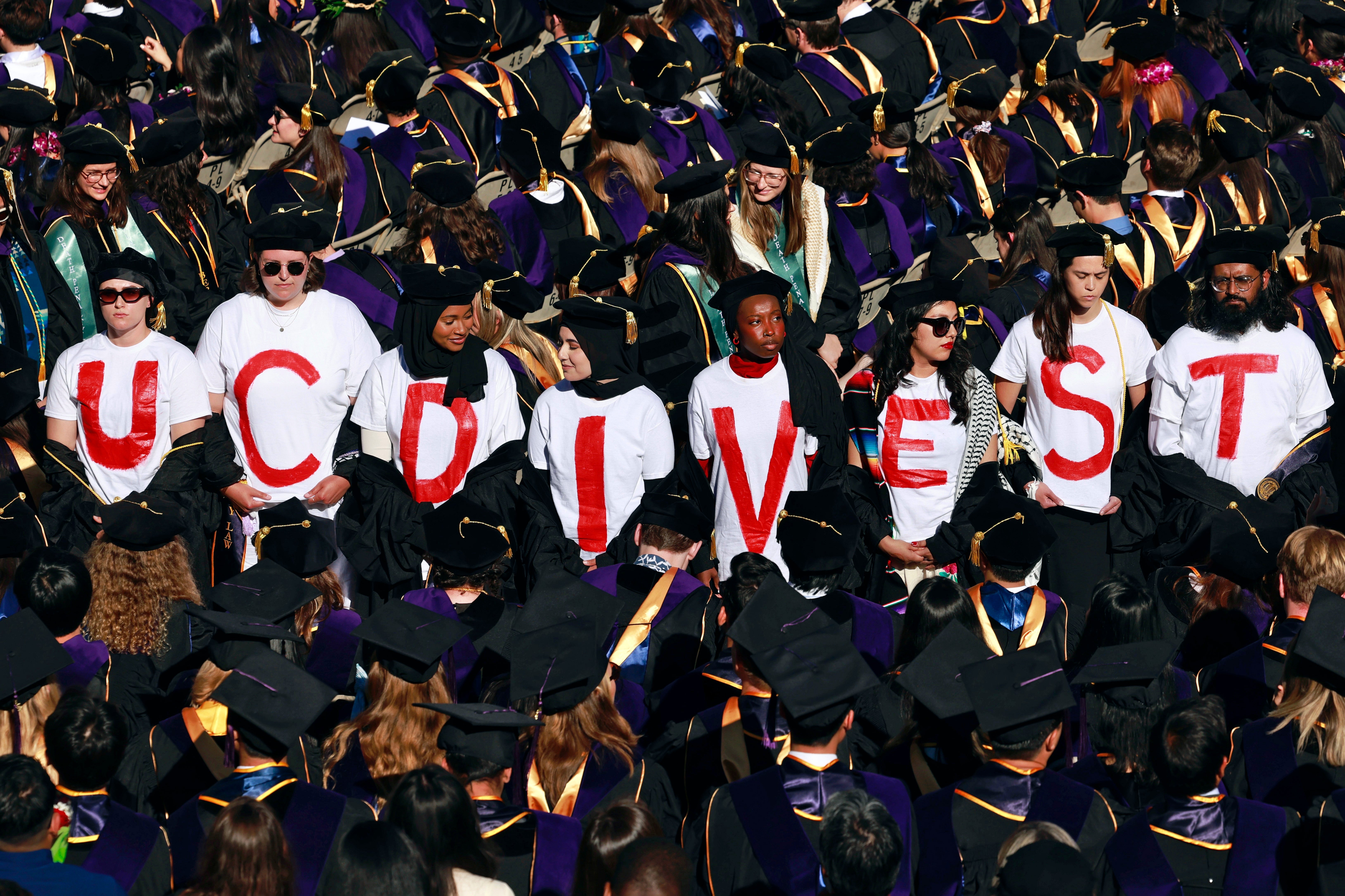 UC Berkeley Law School graduates wear T-shirts that read ‘UC DIVEST’ as a form of protest during the UC Berkeley Law School commencement at the Greek Theater in Berkeley on Friday